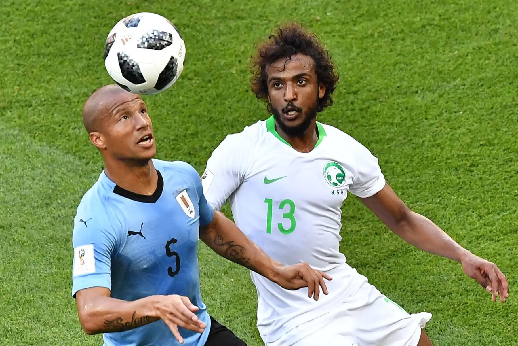 El centrocampista uruguayo Carlos Sánchez (L) pelea por el balón con el defensor de Arabia Saudita Yasser Al-Shahrani durante el partido de fútbol del Grupo A de la Copa Mundial Rusia 2018 entre Uruguay y Arabia Saudita en el Rostov Arena en Rostov-On-Don el 20 de junio de 2018. / AFP