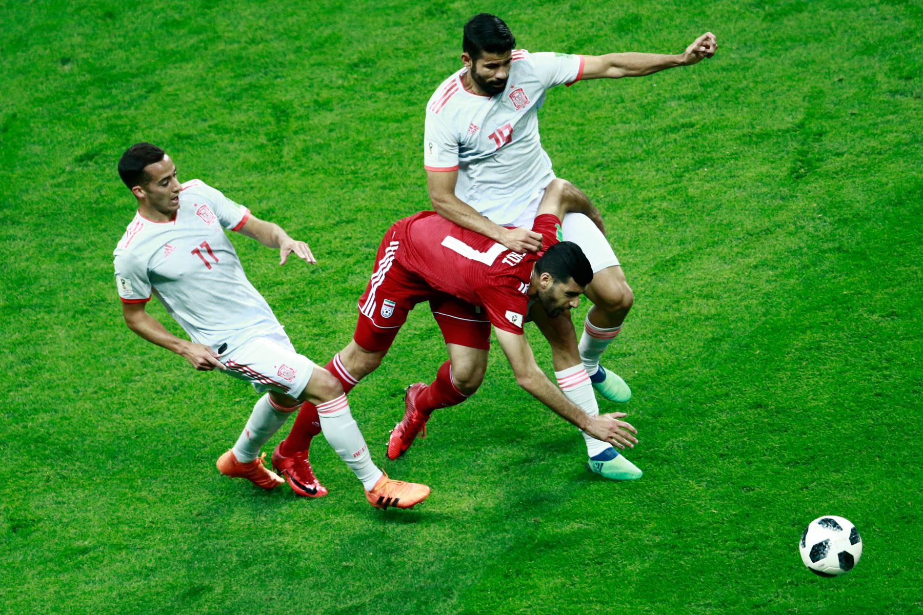 El delantero iraní Mehdi Taremi (C) recibe una falta del alero español Diego Costa (R) durante el partido de fútbol del Grupo B de la Copa Mundial Rusia 2018 entre Irán y España en el Kazan Arena en Kazán el 20 de junio de 2018. / AFP