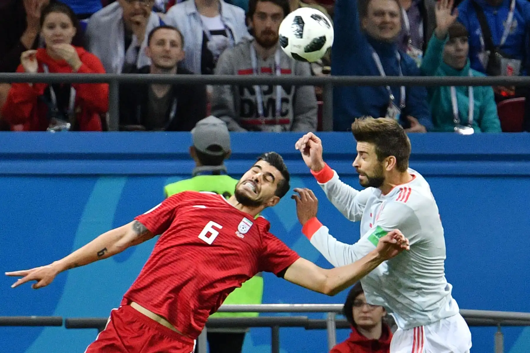El defensor de España Gerard Pique (R) compite por el cabezazo con el centrocampista iraní Saeid Ezatolahi durante el partido de fútbol del Grupo B de la Copa Mundial Rusia 2018 entre Irán y España en el Kazan Arena en Kazán el 20 de junio de 2018. / AFP