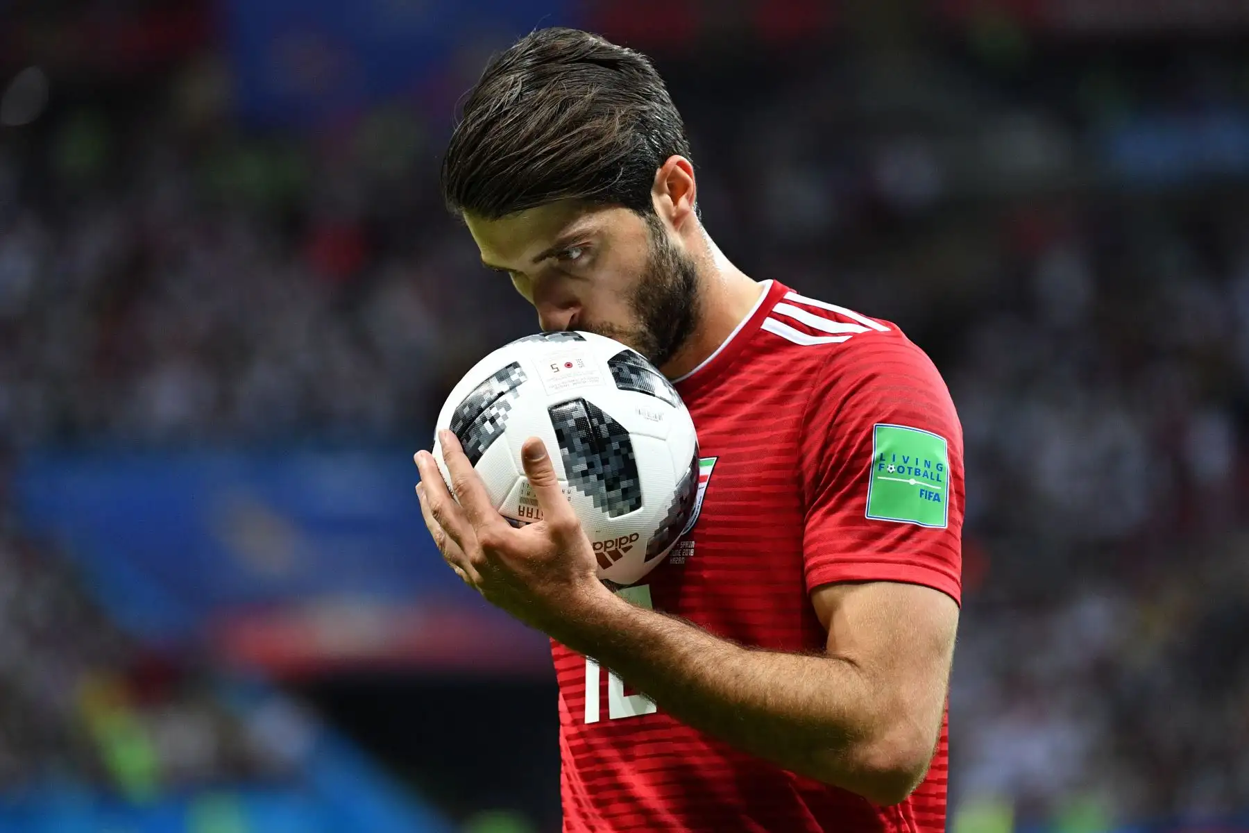 El delantero iraní Karim Ansari Fard besa el balón durante el partido de fútbol del Grupo B de la Copa Mundial Rusia 2018 entre Irán y España. / AFP