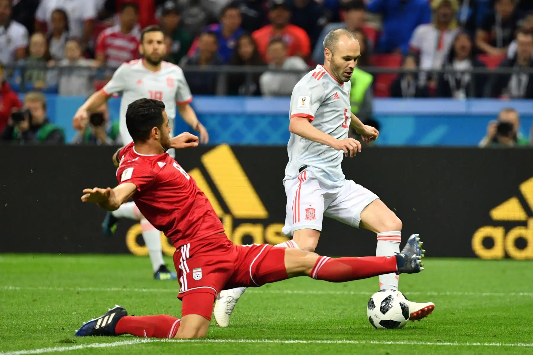 El defensor iraní Morteza Pouraliganji ataja al mediocampista español Andrés Iniesta (R) durante el partido de fútbol del Grupo B de la Copa Mundial Rusia 2018 entre Irán y España en el Kazan Arena en Kazán el 20 de junio de 2018. / AFP