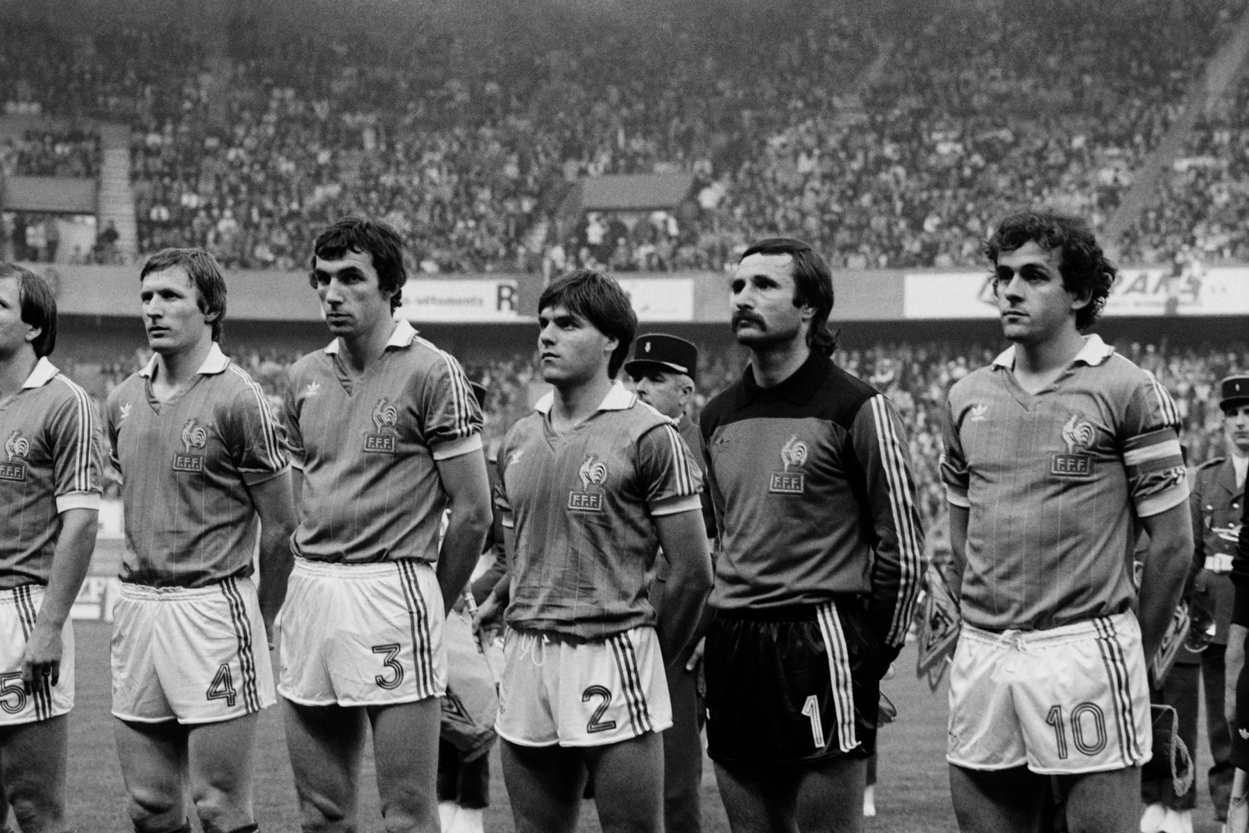 Los jugadores franceses (desde la izquierda), Leonard Specht, Maxime Bossis, Manuel Amoros, Dominique Baratelli y Michel Platini escuchan el himno nacional antes del partido amistoso Francia-Perú en el estadio Parc des Princes en París el 28 de abril de 1982. / AFP