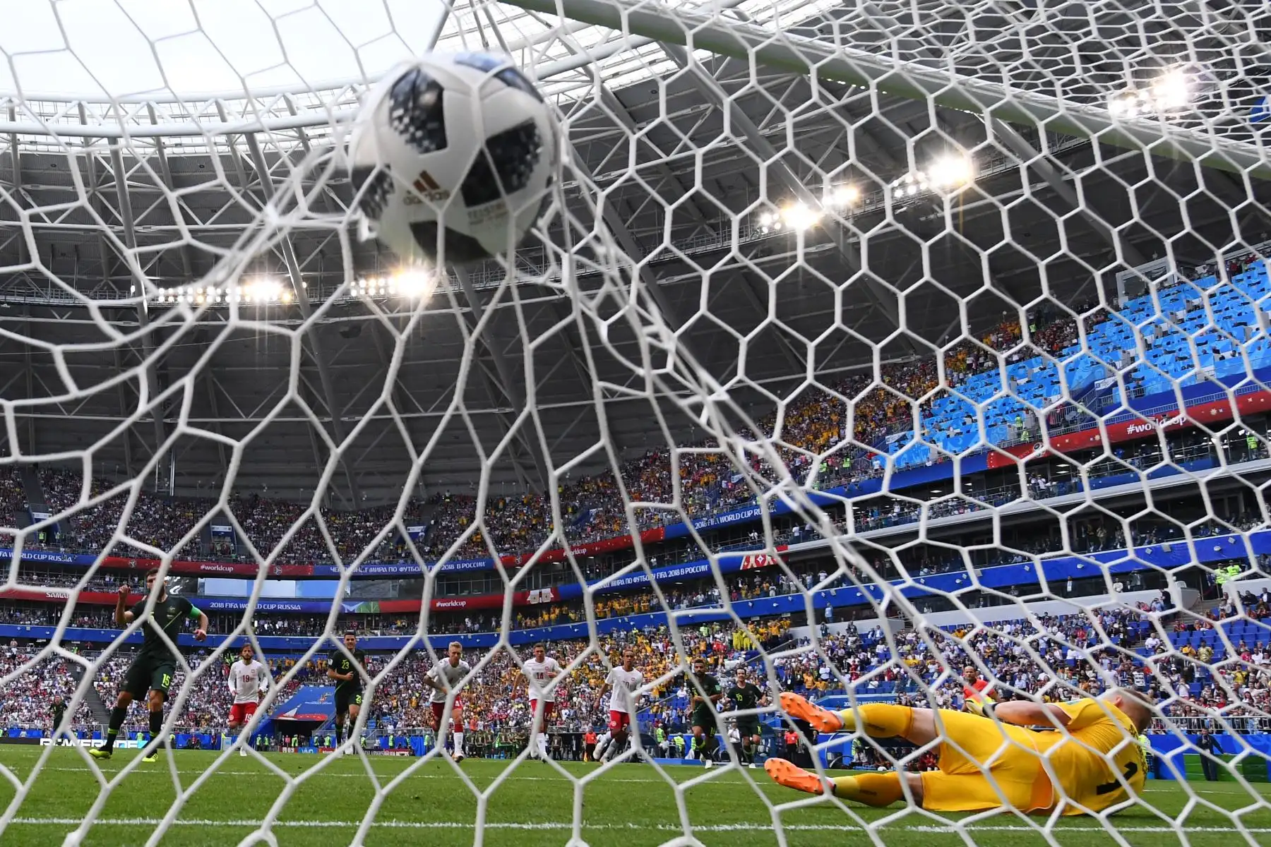 El centrocampista australiano Mile Jedinak (L) marca desde el punto de penalti para el primer gol de Australia igualar 1-1 al guardameta danés Kasper Schmeichel (R) durante el partido de fútbol del Grupo C de la Copa Mundial Rusia 2018 entre Dinamarca y Australia en el Samara Arena en Samara el 21 de junio de 2018. / AFP