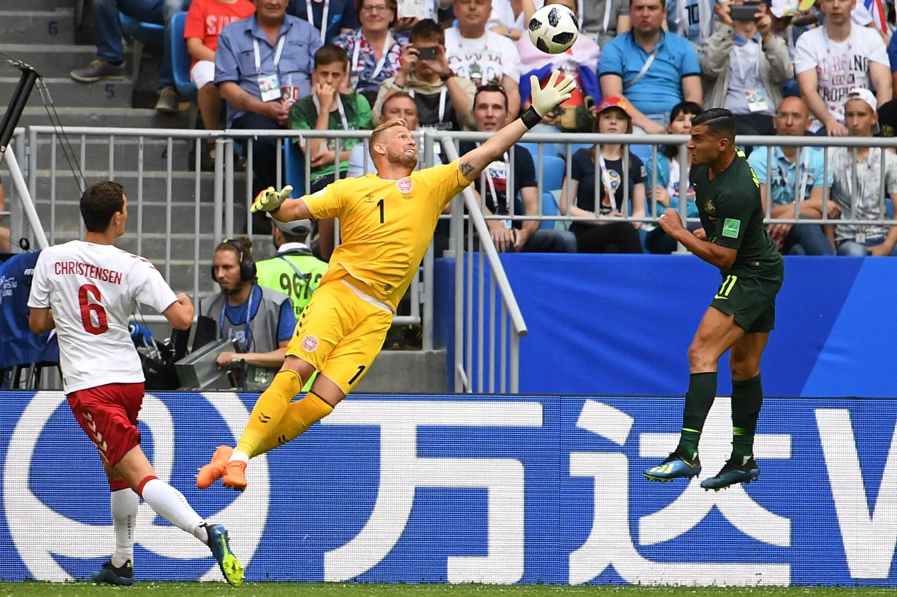 El guardameta danés Kasper Schmeichel (C) viene para una pelota alta contra el alero australiano Andrew Nabbout (R) durante el partido de fútbol del Grupo C de la Copa Rusia 2018 entre Dinamarca y Australia en el Samara Arena en Samara el 21 de junio de 2018. / AFP