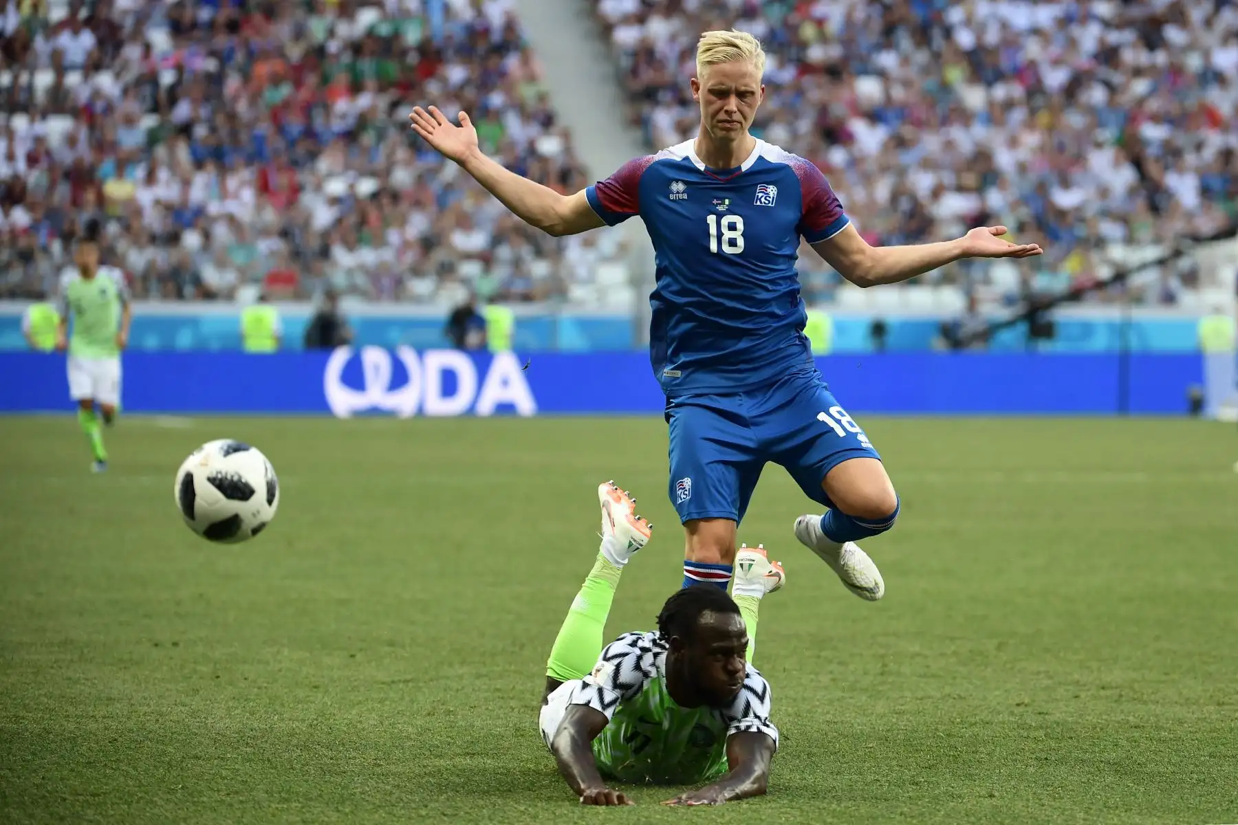 El delantero de Nigeria Victor Moses cae por encima del defensor islandés Hordur Magnusson durante el partido de fútbol del Grupo D de la Copa Mundial Rusia 2018 entre Nigeria e Islandia en el Volgograd Arena de Volgogrado el 22 de junio de 2018. / AFP
