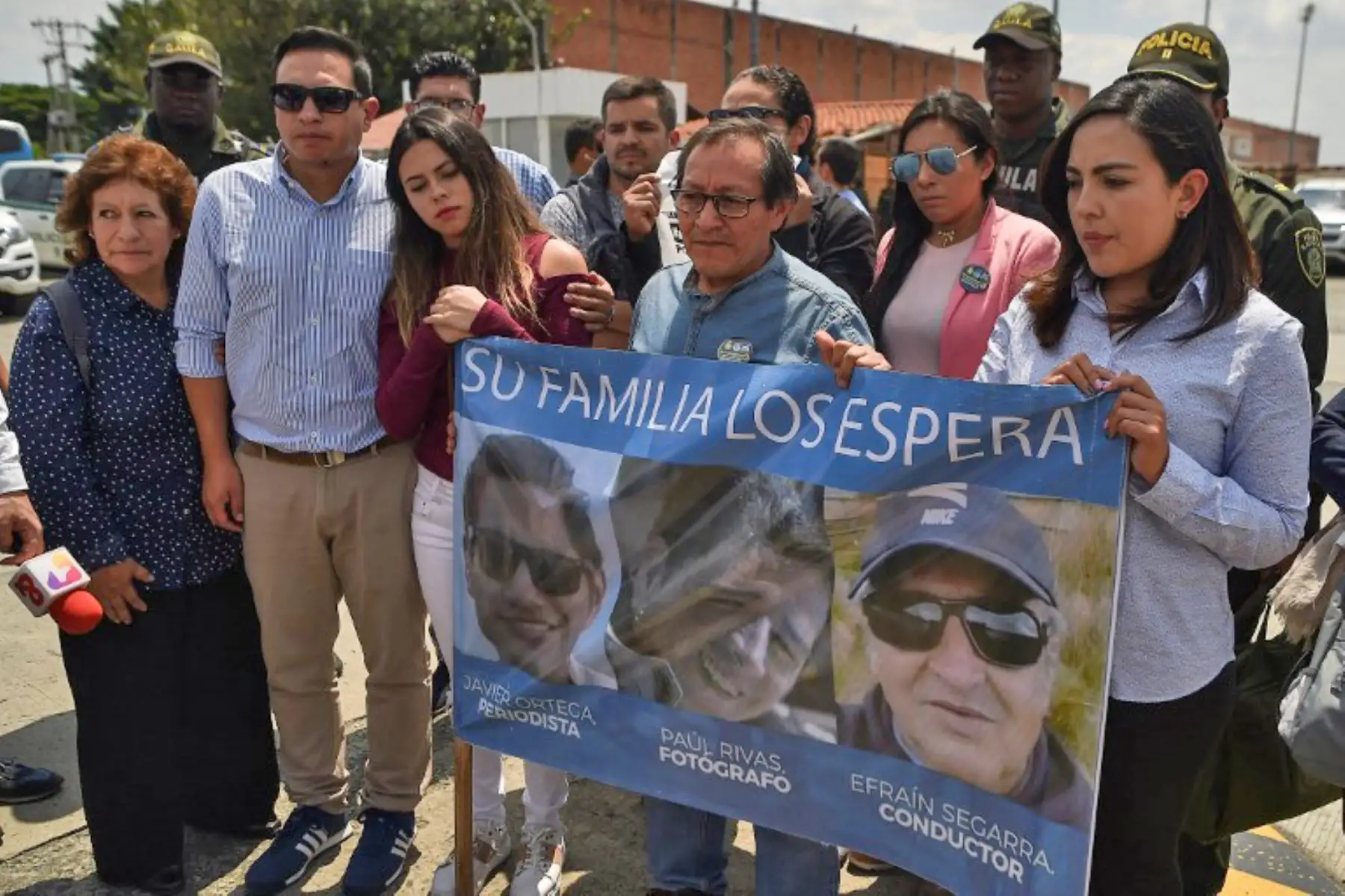 Familiares del asesinado periodista ecuatoriano de El Comercio Javier Ortega, el fotógrafo Paul Rivas y el conductor Efraín Segarra, sostienen una pancarta con sus retratos en el aeropuerto Alfonso Bonilla Aragón en Palmira, Colombia.Foto:AFP