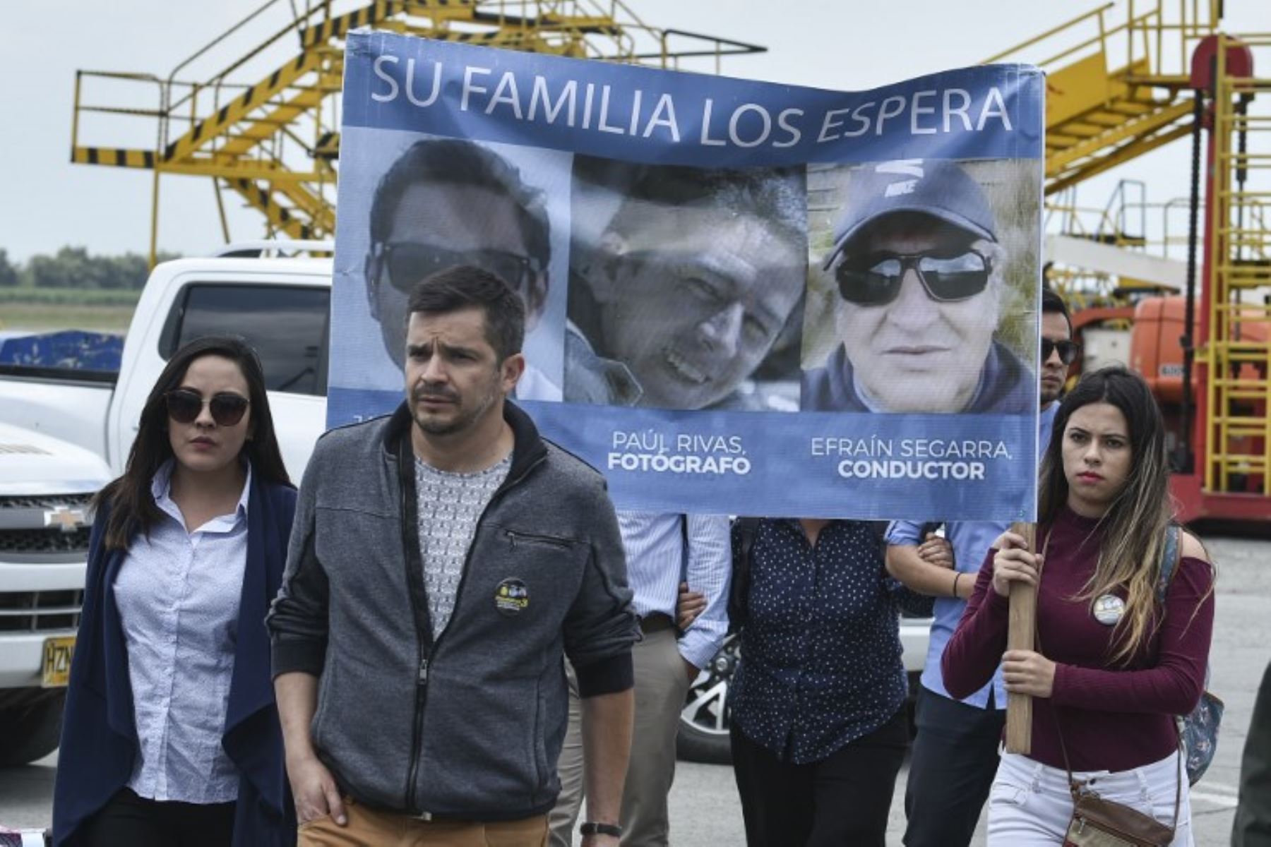 Familiares del asesinado periodista ecuatoriano de El Comercio Javier Ortega, el fotógrafo Paul Rivas y el conductor Efraín Segarra, sostienen una pancarta con sus retratos en el aeropuerto Alfonso Bonilla Aragón en Palmira, Colombia.Foto:AFP