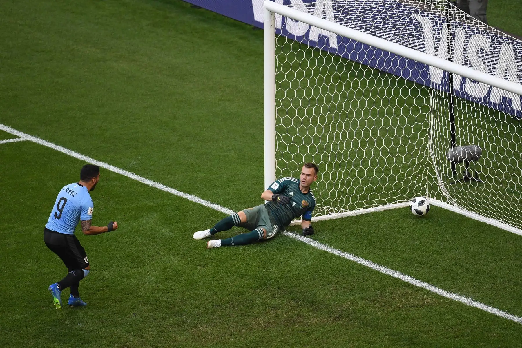 El delantero uruguayo Luis Suarez (L) celebra y el portero ruso Igor Akinfeev (R) reacciona después del segundo gol uruguayo marcado por el defensor uruguayo Diego Laxalt durante el partido de fútbol Rusia A del Grupo A de la Copa Mundial 2018 entre Uruguay y Rusia en el Samara Arena en Samara el 25 de junio , 2018. / AFP