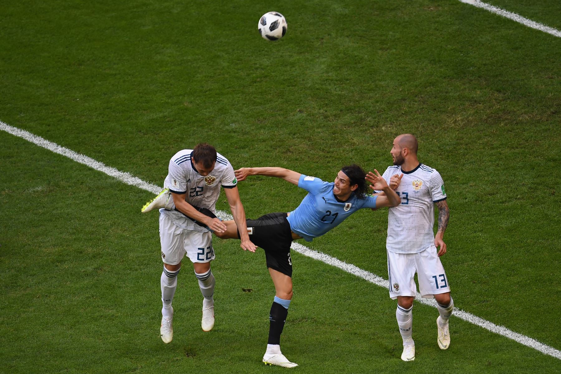 El delantero uruguayo Edinson Cavani (C) pelea con el delantero ruso Artem Dzyuba (L) y el defensor ruso Fyodor Kudryashov (R) durante el partido de fútbol Rusia A del Grupo A de la Copa Mundial 2018 entre Uruguay y Rusia en el Samara Arena de Samara el 25 de junio de 2018. / AFP