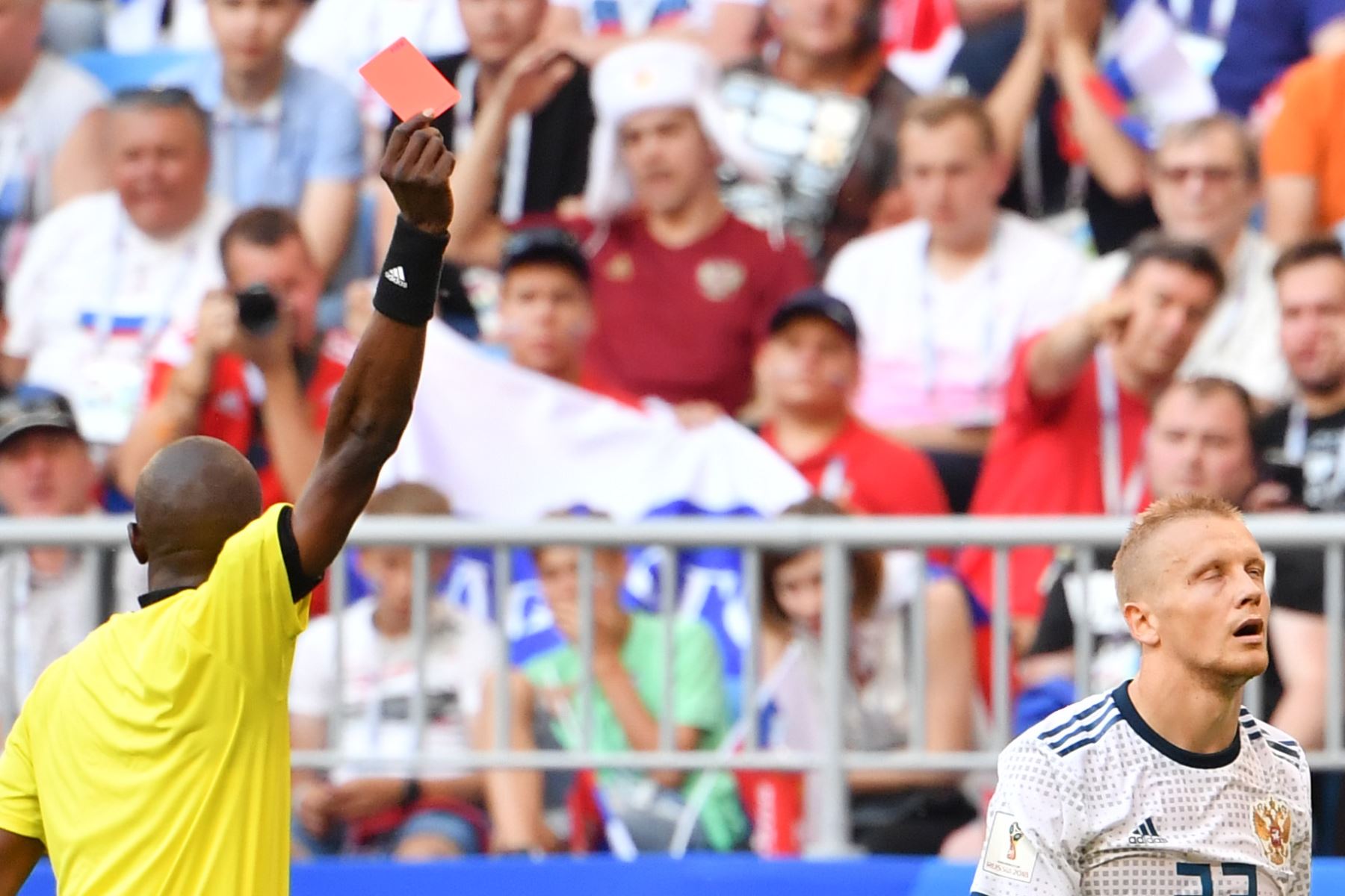 El árbitro senegalés Malang Diedhiou muestra una tarjeta roja al defensor ruso Igor Smolnikov (R) durante el partido de fútbol del Grupo A de la Copa Mundial Rusia 2018 entre Uruguay y Rusia en el Samara Arena en Samara el 25 de junio de 2018. / AFP
