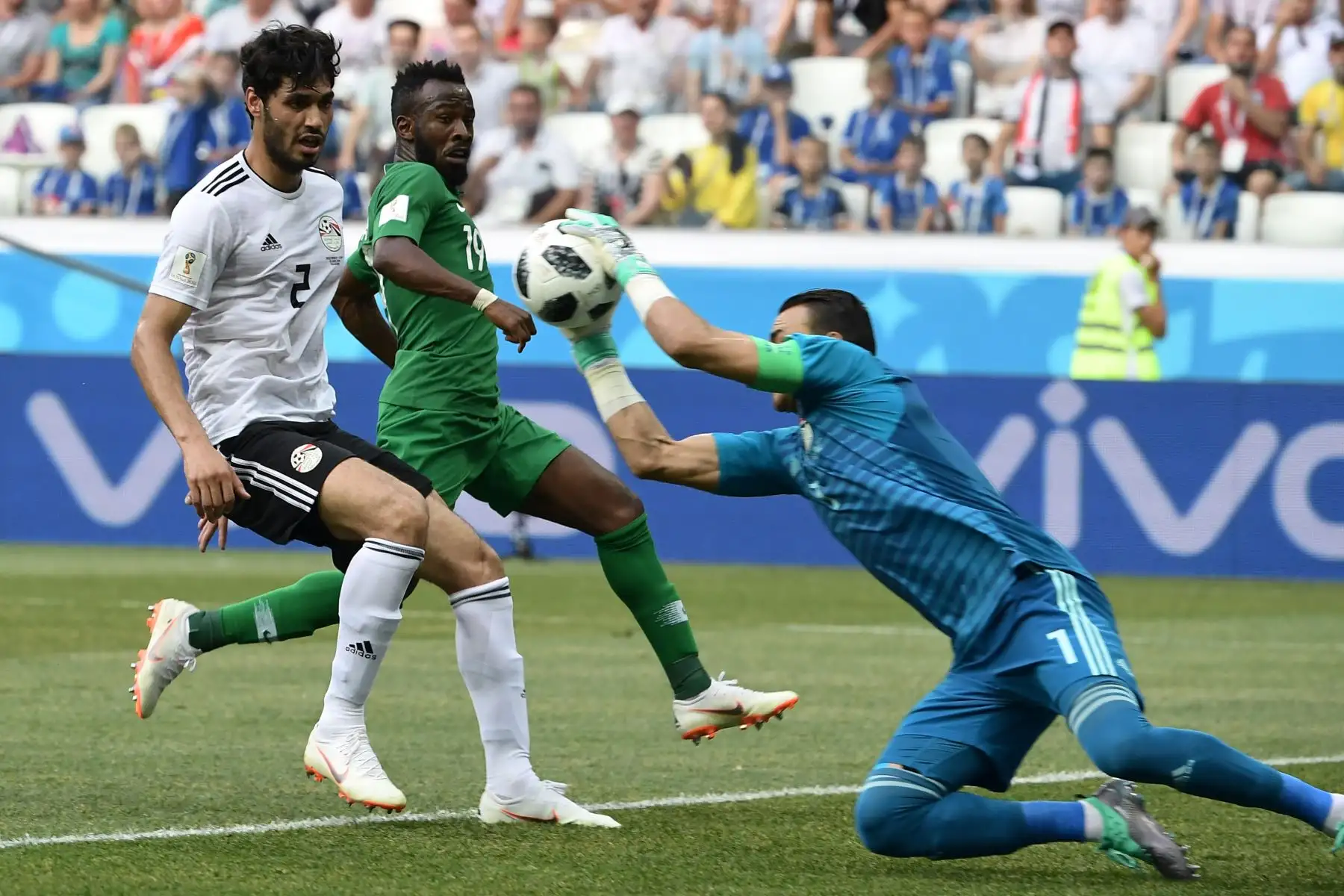 El arquero egipcio Essam El Hadary (R) detiene un tiro mientras el defensor egipcio Ali Gabr (L) y el alero saudí Fahad Al-Muwallad observan durante el partido de fútbol del Grupo A de Rusia A 2018 entre Arabia Saudita y Egipto en el Volgograd Arena de Volgogrado el 25 de junio de 2018. / AFP