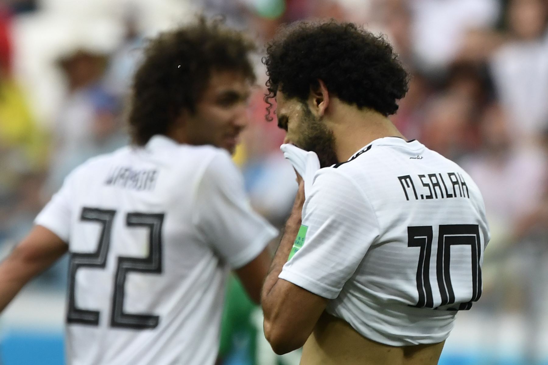 El delantero egipcio Mohamed Salah (R) se limpia la cara durante el partido de fútbol de la Copa Mundial Rusia 2018 entre Arabia Saudita y Egipto en el Volgograd Arena de Volgogrado el 25 de junio de 2018. / AFP