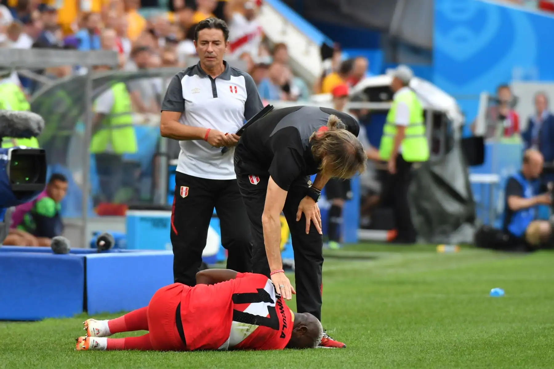 El defensor peruano Luis Advincula (abajo) es revisado por el técnico peruano Ricardo Gareca (R) durante el partido de fútbol del Grupo C de la Copa Mundial Rusia 2018 entre Australia y Perú en el Estadio Fisht en Sochi el 26 de junio de 2018.
Nelson Almeida / AFP
