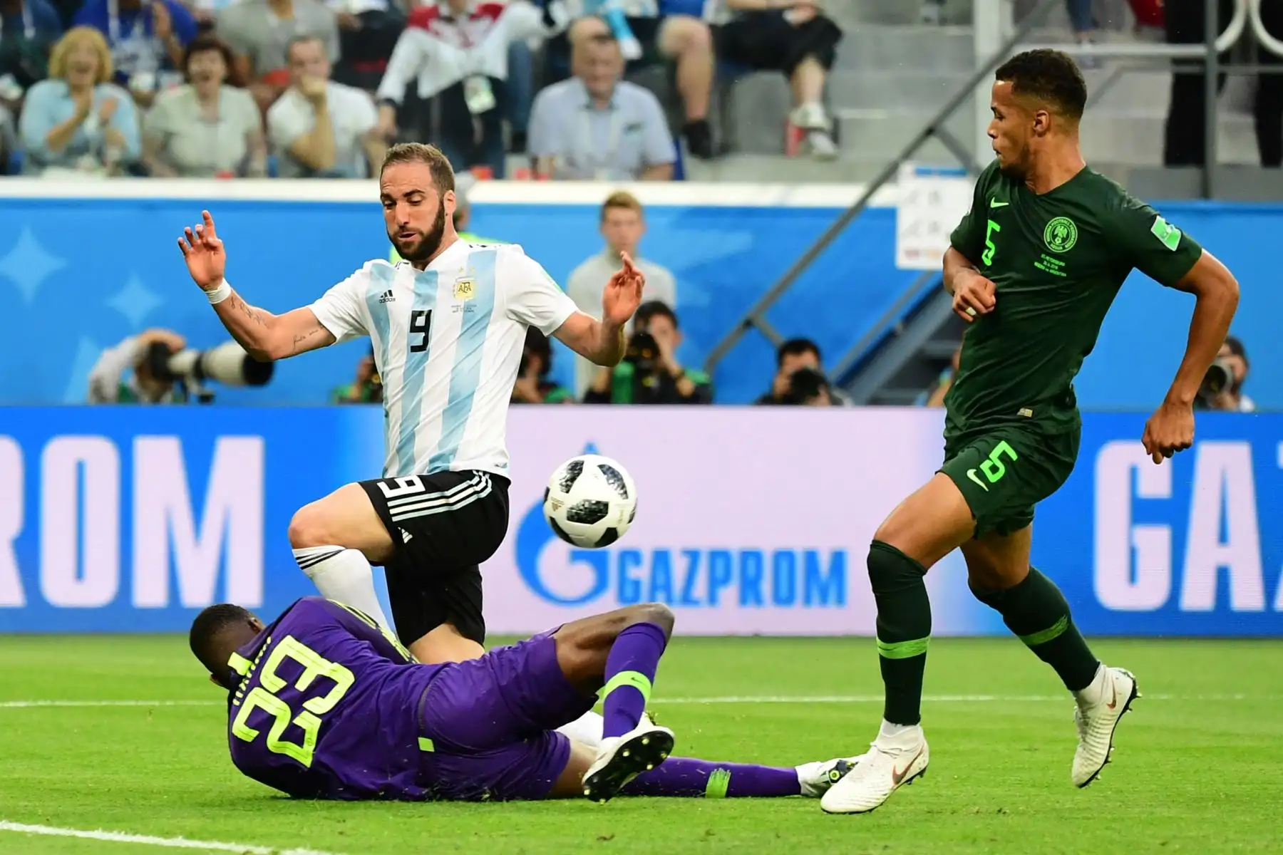 El portero de ANigeria Francis Uzoho (L) choca con el delantero argentino Gonzalo Higuaín (C) durante el partido de fútbol del Grupo D de la Copa Mundial Rusia 2018 entre Nigeria y Argentina en el Estadio de San Petersburgo el 26 de junio de 2018. / AFP