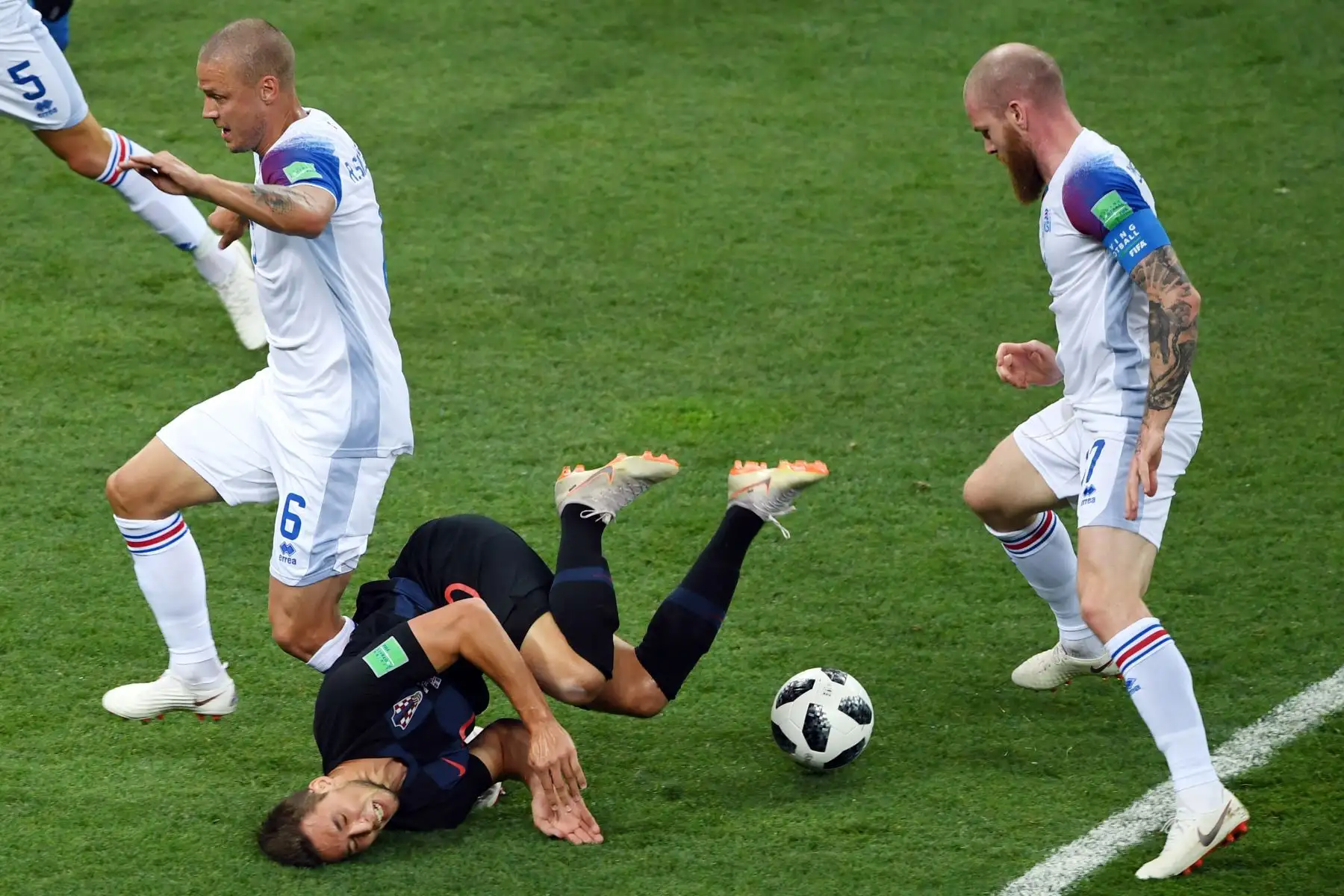 El delantero croata Marko Pjaca (C) cae después de desafiar al defensor islandés Ragnar Sigurdsson y al centrocampista islandés Aron Gunnarsson (R) durante el partido de fútbol del Grupo D de la Copa Mundial Rusia 2018 entre Islandia y Croacia en el Rostov Arena en Rostov-On-Don el 26 de junio. 2018. / AFP