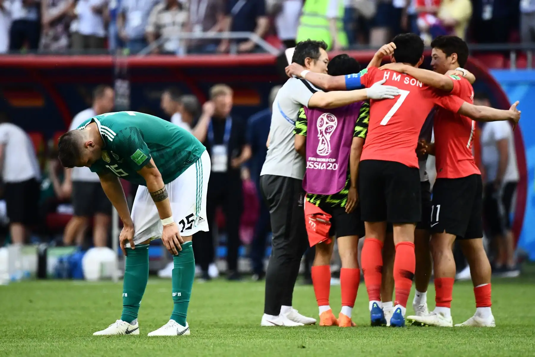 El defensor de Alemania Niklas Suele, desalentado, cerca de los jugadores del equipo de Corea del Sur que celebran al final del partido de fútbol del grupo F de la Copa Mundial Rusia 2018 entre Corea del Sur y Alemania en el Kazan Arena, el 27 de junio del 2018. Foto: AFP.
