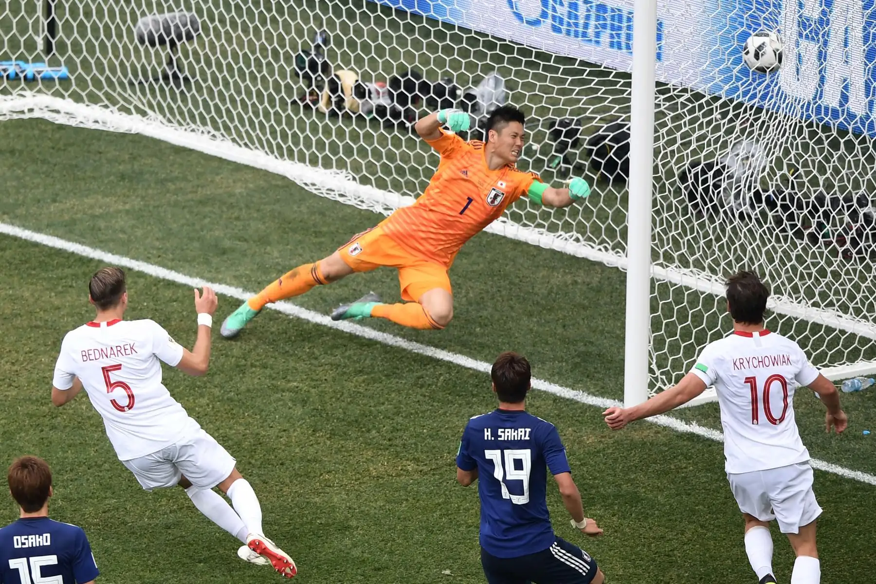 El defensor polaco Jan Bednarek (L) marca el gol de apertura después del portero japonés Eiji Kawashima (arriba) durante el partido de fútbol Rusia 2018 Grupo H de fútbol entre Japón y Polonia en el Volgograd Arena en Volgogrado el 28 de junio de 2018. / AFP