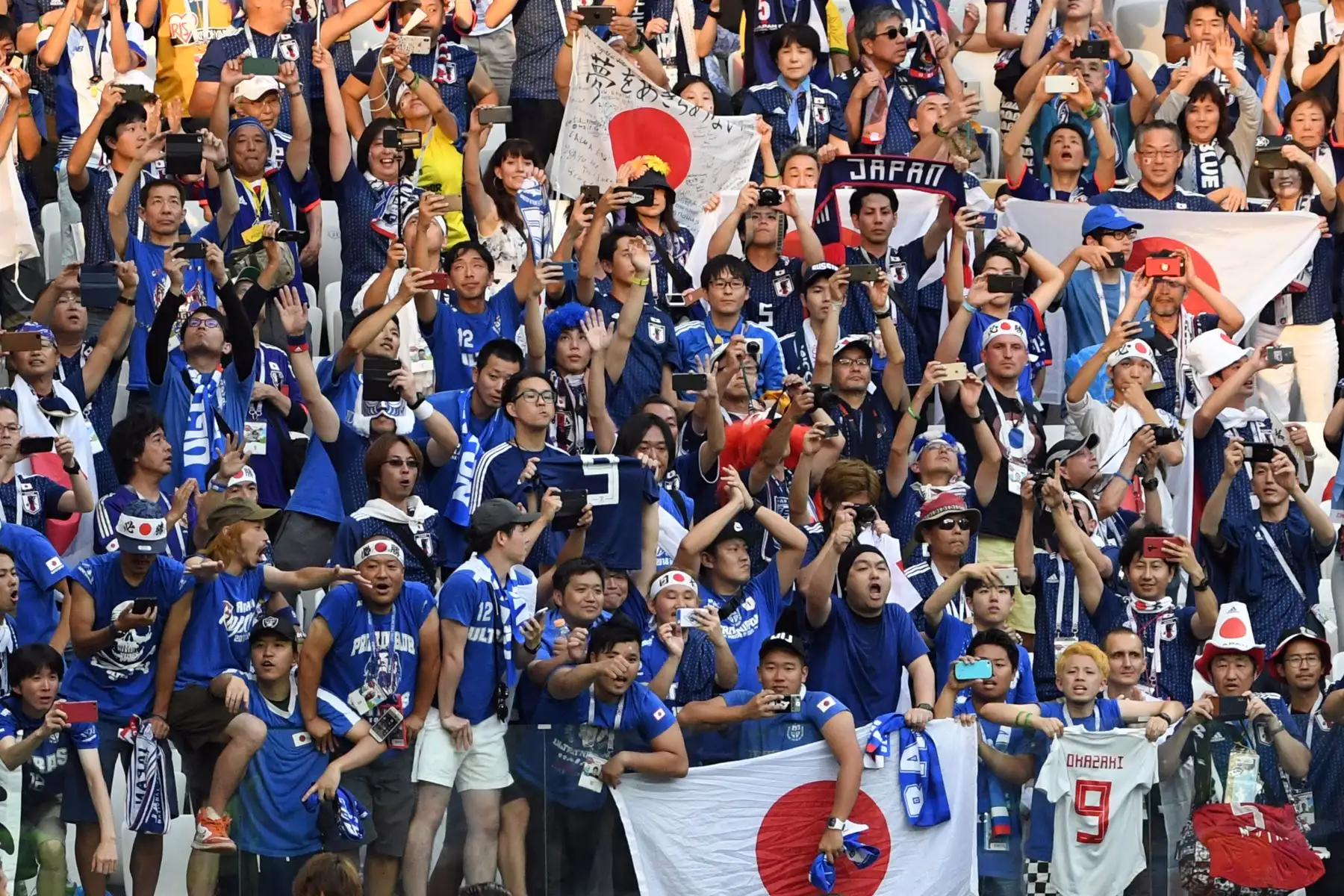 Los fanáticos de Japón celebran la clasificación de su equipo para la siguiente ronda al final del partido de fútbol del Grupo H Rusia 2018 entre Japón y Polonia en el Volgograd Arena de Volgogrado el 28 de junio de 2018. / AFP