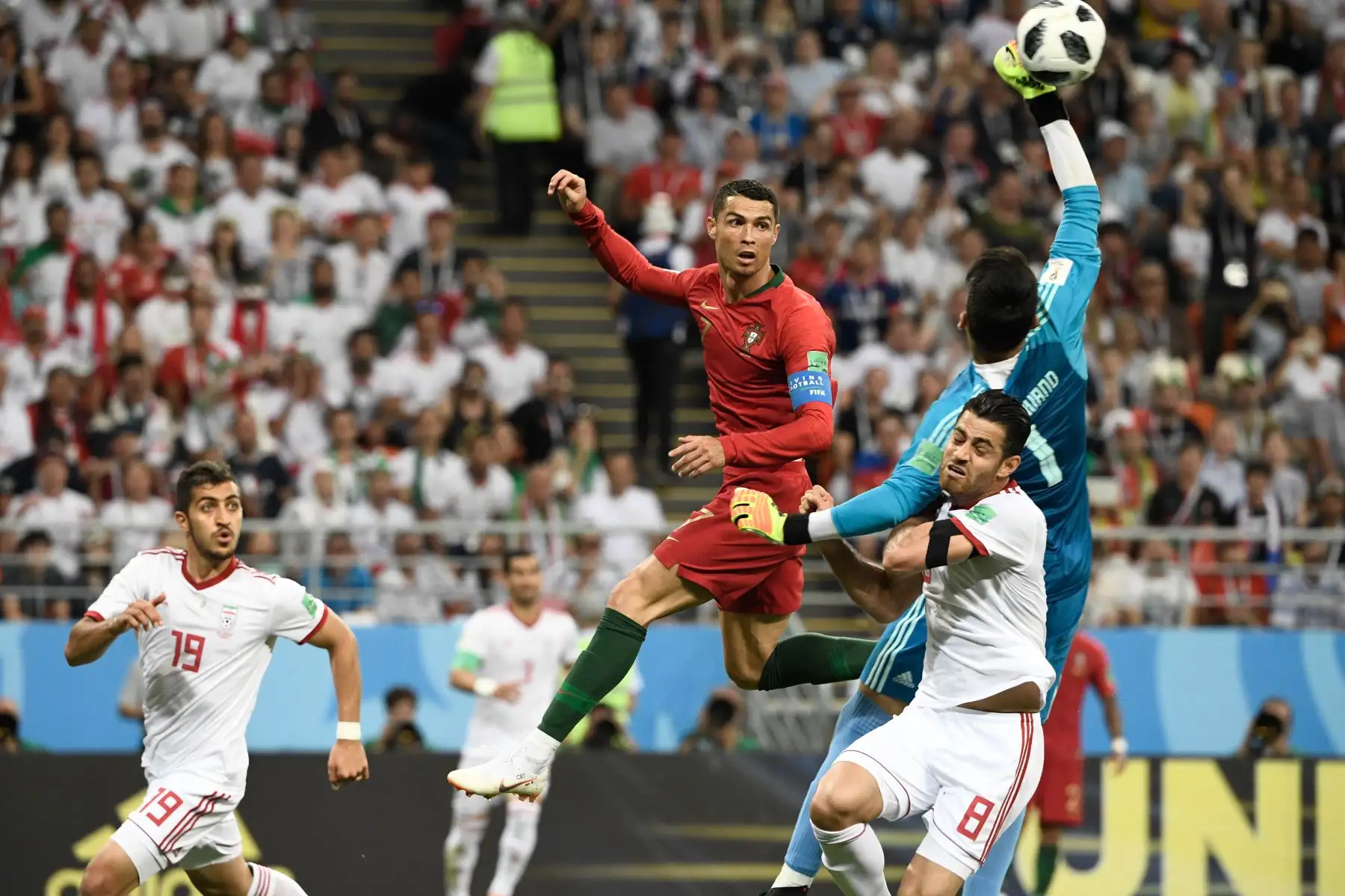 El delantero portugués Cristiano Ronaldo y el portero iraní Alireza Beiranvand (C) compiten por el balón durante el partido de fútbol del Grupo B de la Copa Mundial Rusia 2018 entre Irán y Portugal en el Mordovia Arena en Saransk el 25 de junio de 2018. Foto: AFP