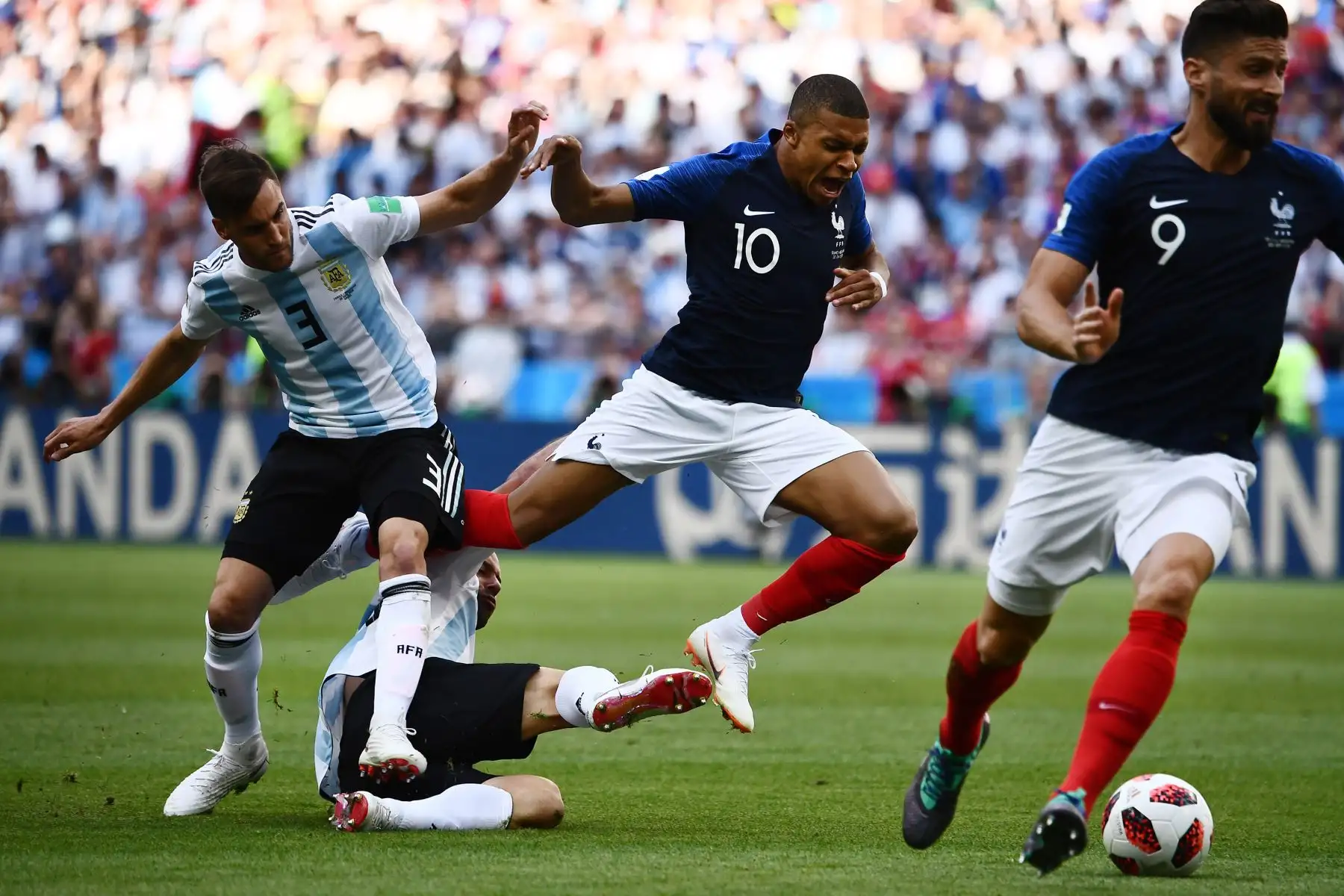 El delantero francés Kylian Mbappe (2 ° R) es tackleado por el defensa argentino Nicolas Tagliafico (L) y el centrocampista argentino Javier Mascherano (2 ° L, abajo) durante la ronda de octavos de final de la Copa Mundial Rusia 2018 entre Francia y Argentina en el Kazan Arena en Kazan el 30 de junio de 2018. / AFP