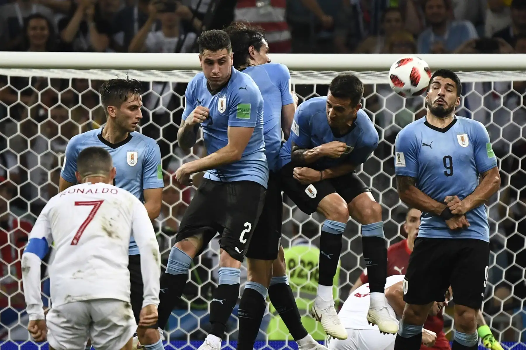 El delantero uruguayo Luis Suárez (derecha) saltará para detener un tiro libre del delantero portugués Cristiano Ronaldo (delantero) durante la ronda de octavos de final de la Copa Mundial Rusia 2018 entre Uruguay y Portugal en el estadio Fisht de Sochi el 30 de junio de 2018.
/ AFP
