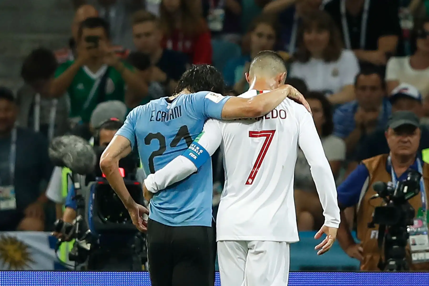 El alero de Portugal Cristiano Ronaldo (R) ayuda al delantero uruguayo Edinson Cavani después de que se recuperó de una lesión durante la ronda de octavos de final de la Copa Mundial Rusia 2018 entre Uruguay y Portugal en el Estadio Fisht en Sochi el 30 de junio de 2018. AFP