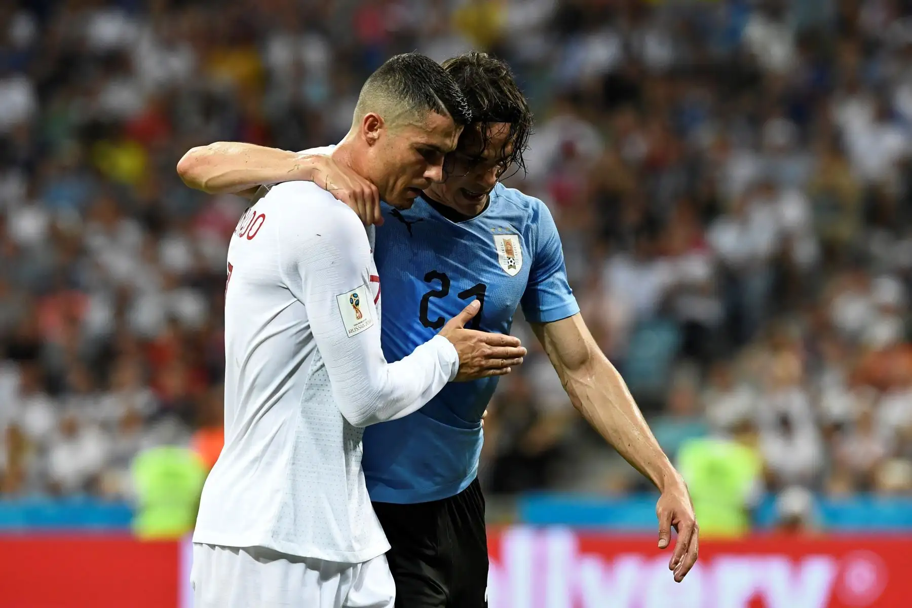 El alero de Portugal Cristiano Ronaldo (R) ayuda al delantero uruguayo Edinson Cavani después de que se recuperó de una lesión durante la ronda de octavos de final de la Copa Mundial Rusia 2018 entre Uruguay y Portugal en el Estadio Fisht en Sochi el 30 de junio de 2018.AFP