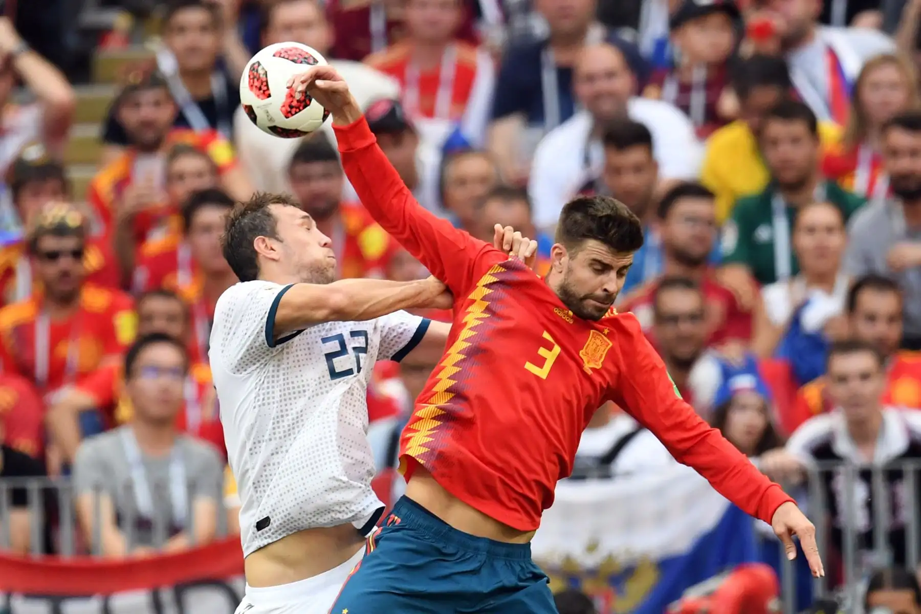El delantero ruso Artem Dzyuba (L) compite con el defensa español Gerard Piqué durante la ronda de rondas 16 de la Copa Mundial Rusia 2018 entre España y Rusia en el Estadio Luzhniki de Moscú el 1 de julio de 2018. / AFP