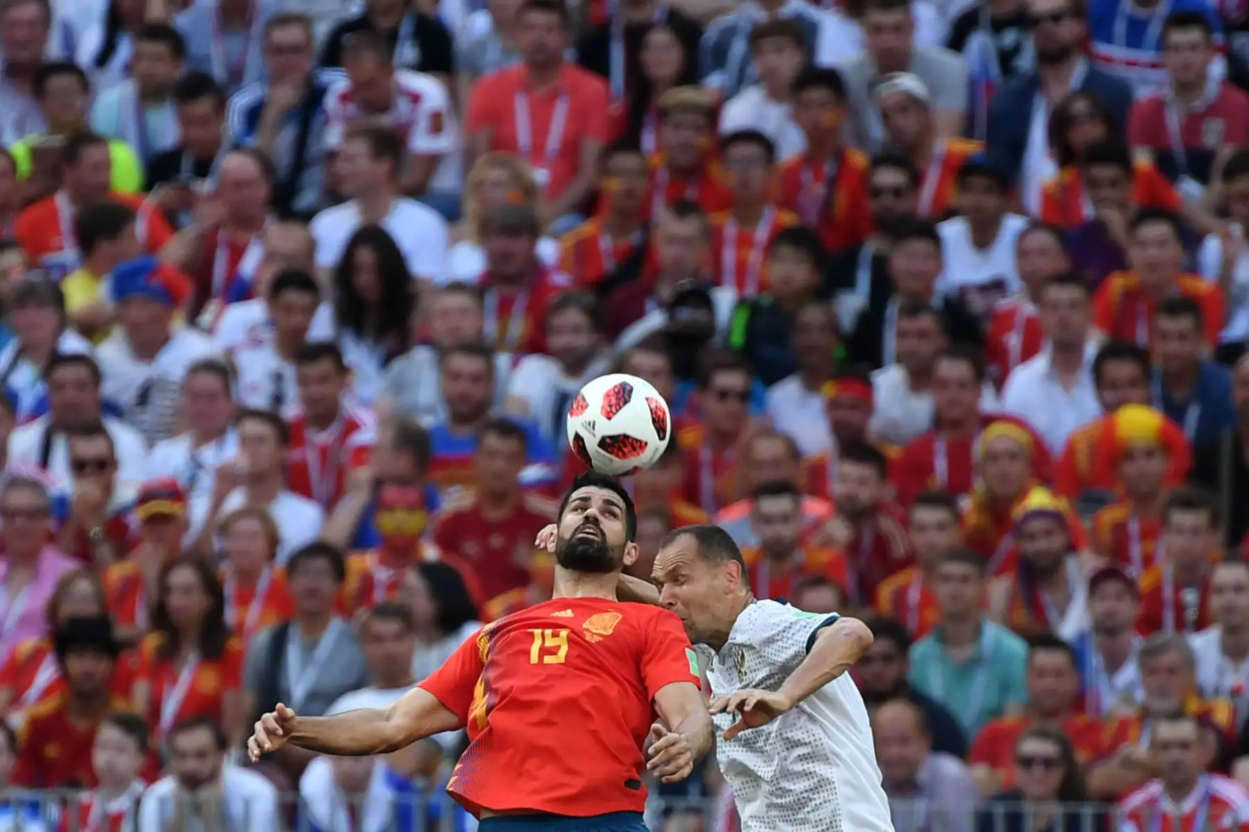 El delantero español Diego Costa (L) encabeza la pelota con el defensor ruso Sergey Ignashevich durante la ronda de octavos de final de la Copa Mundial Rusia 2018 entre España y Rusia en el Estadio Luzhniki en Moscú el 1 de julio de 2018. / AFP