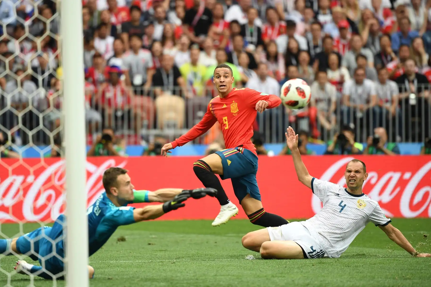 El delantero español Rodrigo (C) y el defensor ruso Sergey Ignashevich (R) ven el balón al entrenador ruso Stanislav Cherchesov durante la ronda de octavos de final de la Copa Mundial Rusia 2018 entre España y Rusia en el Estadio Luzhniki en Moscú el 1 de julio de 2018.
YURI CORTEZ / AFP