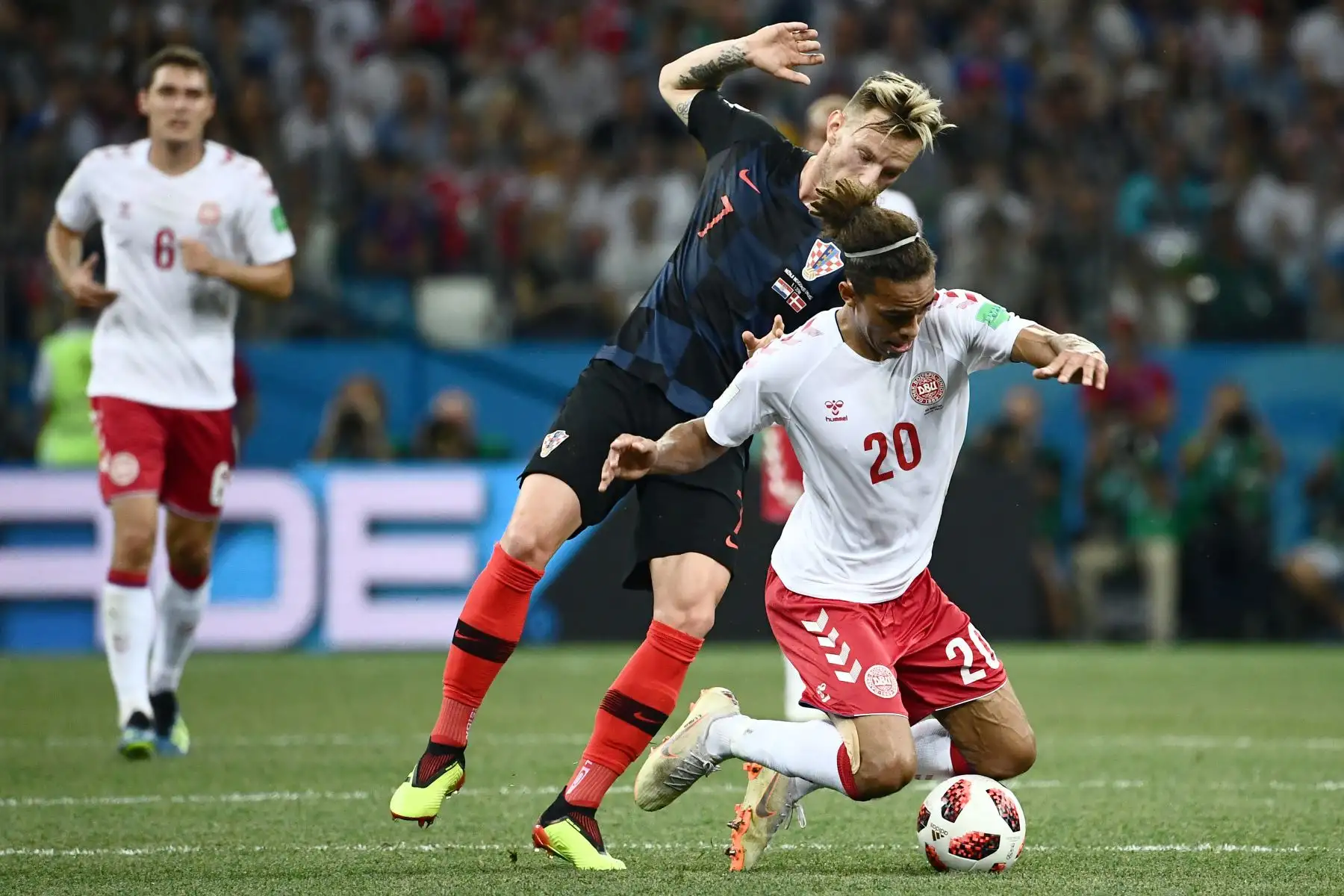 El delantero danés Yussuf Poulsen (R) reta al mediocampista croata Ivan Rakitic durante la ronda de octavos de final de la Copa Mundial Rusia 2018 entre Croacia y Dinamarca en el Estadio Nizhny Novgorod en Nizhny Novgorod el 1 de julio de 2018. / AFP