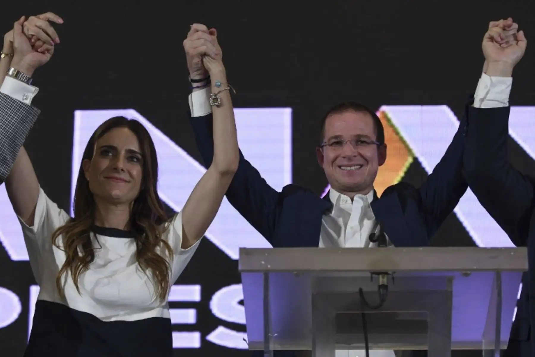 El candidato presidencial de México a la coalición "México al Frente" Ricardo Anaya, y su esposa Carolina Martínez, levantaron la mano durante una conferencia de prensa luego de obtener los resultados preliminares de las elecciones generales en Ciudad de México .Foto:AFP