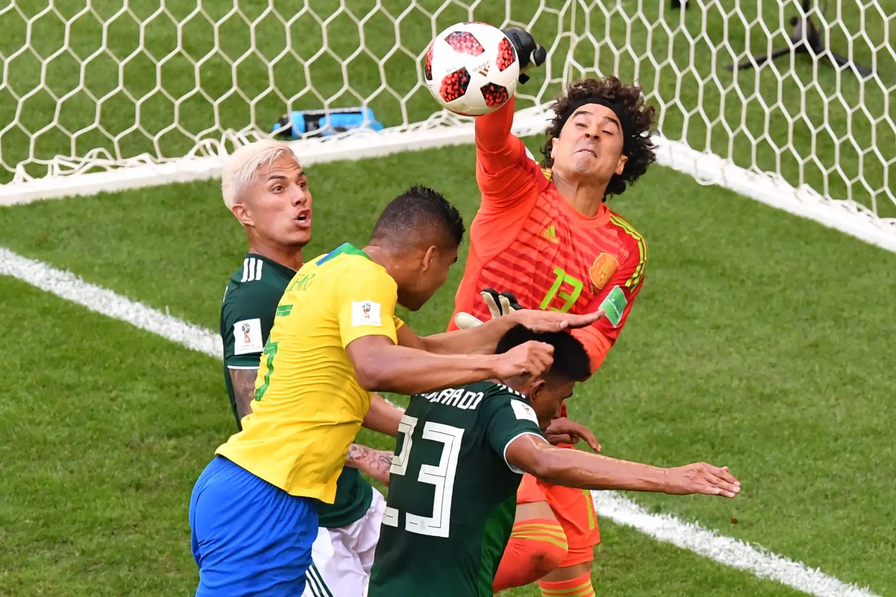 El portero de México Guillermo Ochoa (R) golpea el balón por delante del centrocampista brasileño Casemiro (L) durante la ronda de dieciseisavos de final de la Copa Mundial Rusia 2018 entre Brasil y México en el Samara Arena en Samara el 2 de julio de 2018.
 / AFP