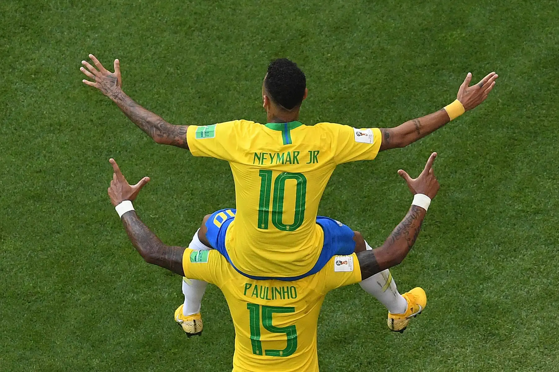 El delantero brasileño Neymar celebra el gol de apertura en el hombro del mediocampista brasileño Paulinho durante la ronda de dieciseisavos de final de la Copa Mundial Rusia 2018 entre Brasil y México en el Samara Arena en Samara el 2 de julio de 2018.
 / AFP
