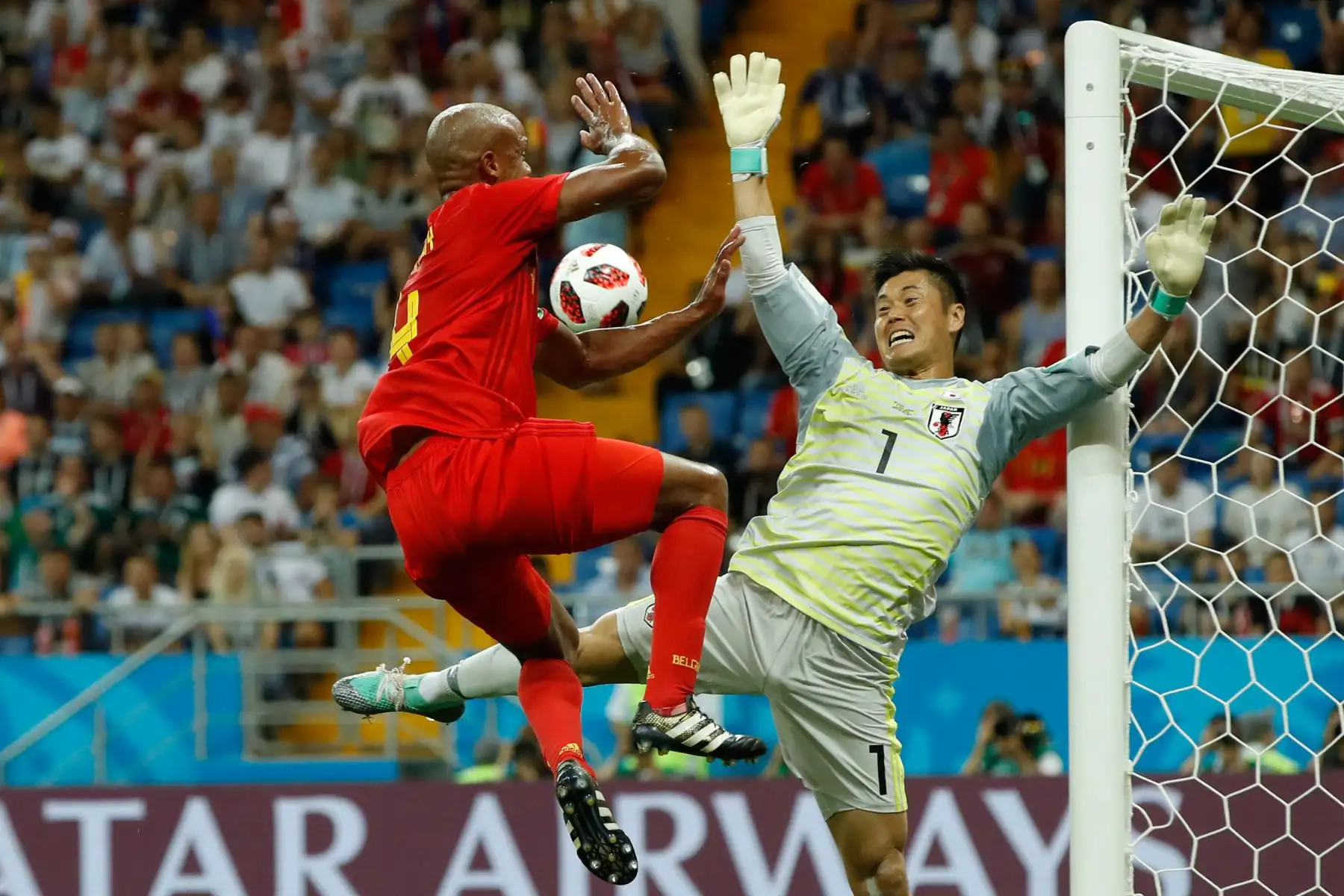 El defensa belga Vincent Kompany (L) intenta anotar contra el portero Eiji Kawashima de Japón durante la ronda de dieciséis rondas de la Copa Mundial de Rusia 2018 entre Bélgica y Japón en el Rostov Arena en Rostov-On-Don el 2 de julio de 2018. / AFP