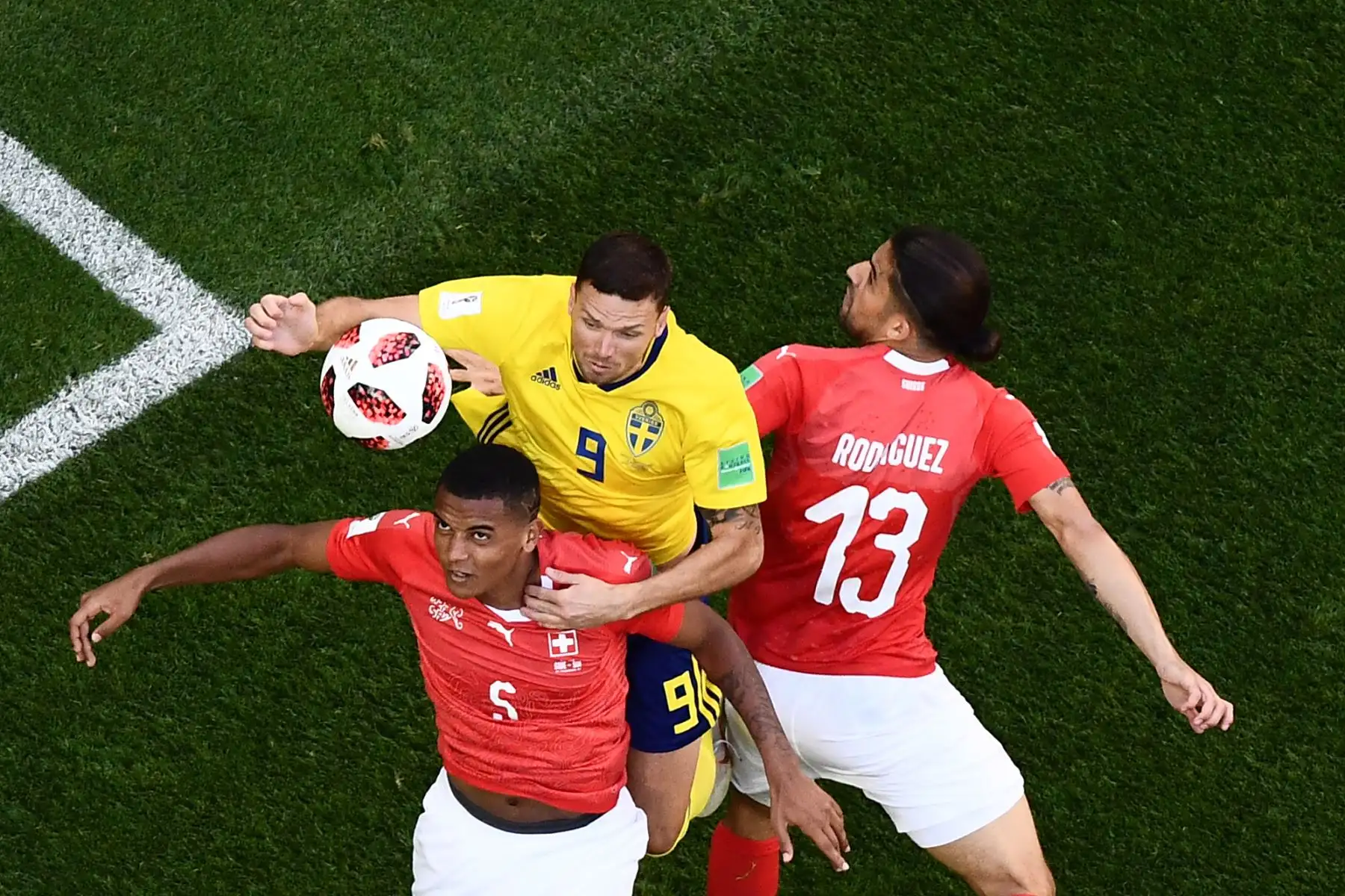 El delantero sueco Marcus Berg (C) compite con el defensa suizo Manuel Akanji (L) y el defensor suizo Ricardo Rodríguez durante la ronda de octavos de final de la Copa Mundial Rusia 2018 entre Suecia y Suiza en el estadio San Petersburgo el 3 de julio de 2018. / AFP
