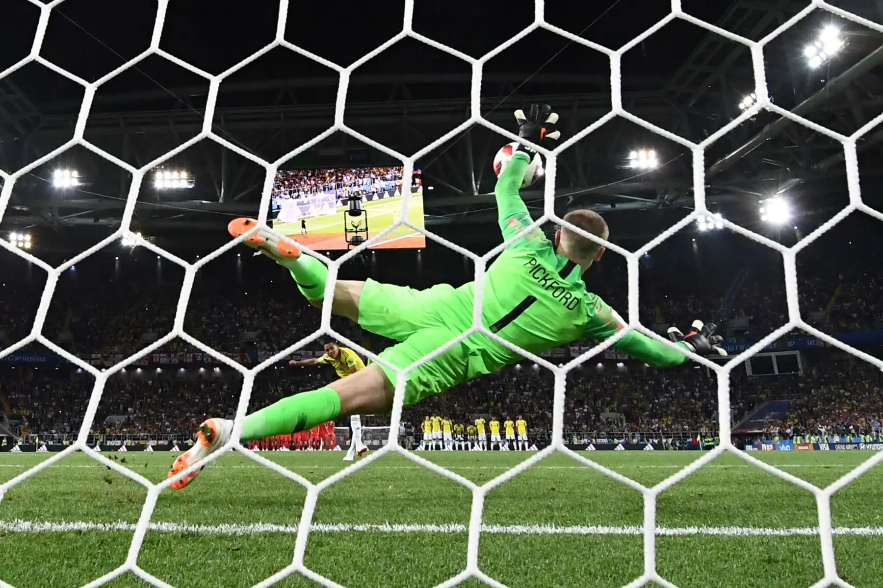 El portero de Inglaterra Jordan Pickford (C) salta para atrapar el balón mientras el alero colombiano Carlos Bacca falla su tiro penal (parte trasera C) durante la tanda de penaltis de la ronda de octavos de final de Rusia 2018 entre Colombia e Inglaterra en el Spartak Stadium en Moscú el 3 de julio de 2018. / AFP