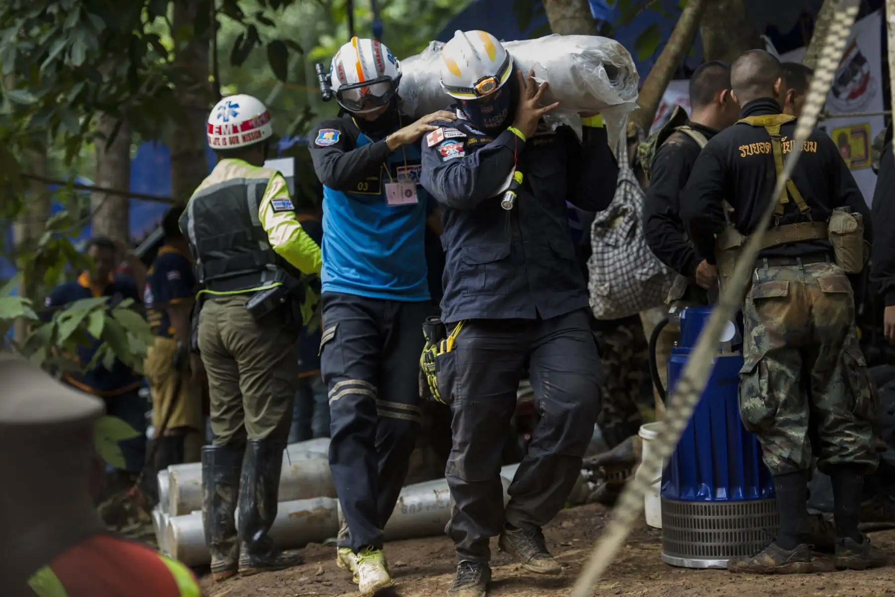 Los trabajadores de rescate llevan suministros durante las operaciones para 12 niños y su entrenador atrapado en la cueva de Tham Luang cerca de la cueva Tham Luang en el parque Khun Nam Nang Non Forest en el distrito Mae Sai de la provincia de Chiang Rai el 4 de julio de 2018. AFP