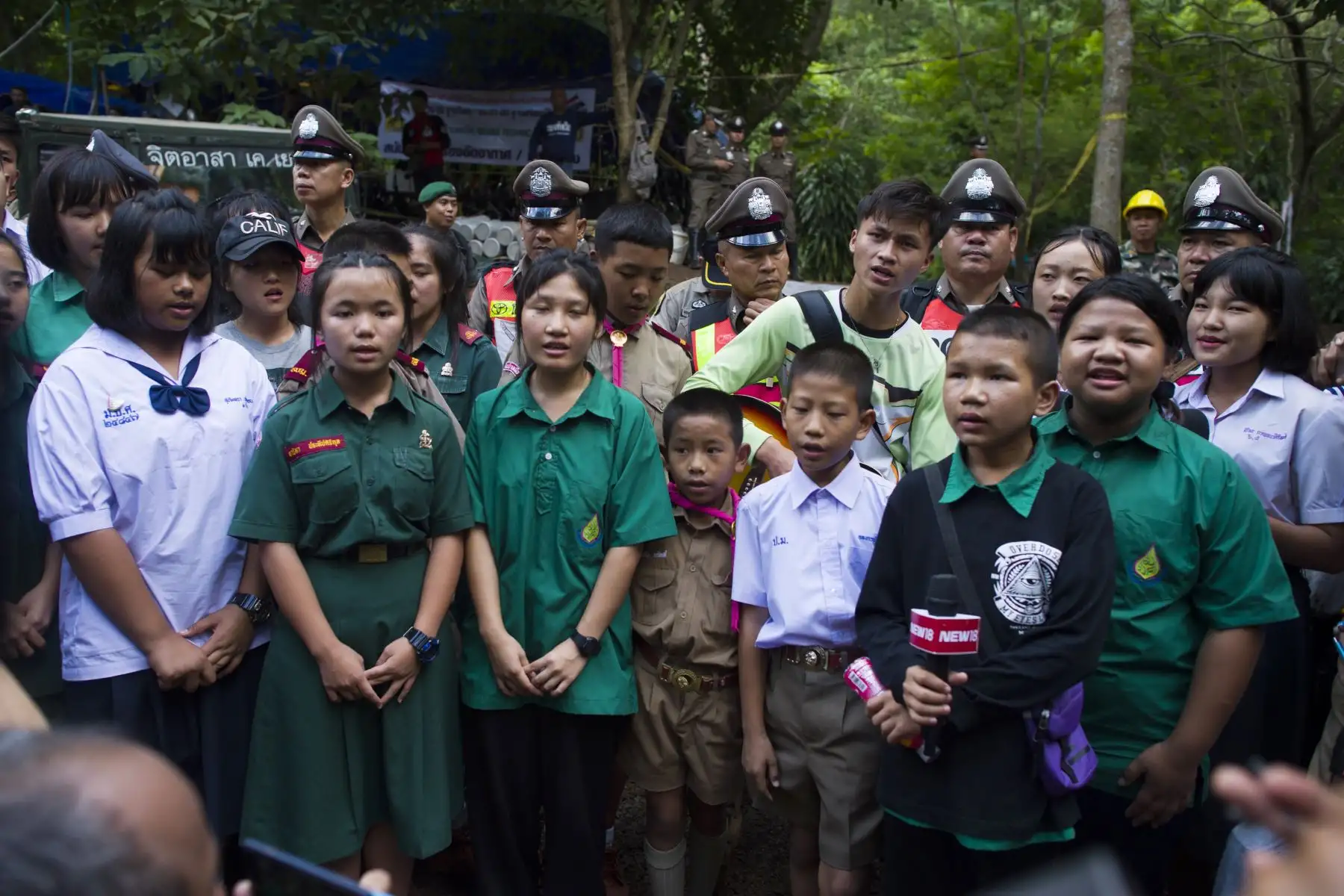 Los escolares cantan en el área de la cueva de Tham Luang durante las operaciones de rescate de 12 niños y su entrenador atrapado en la cueva en el Khun Nam Nang Non Forest Park en el distrito de Mae Sai de la provincia de Chiang Rai el 4 de julio de 2018. AFP