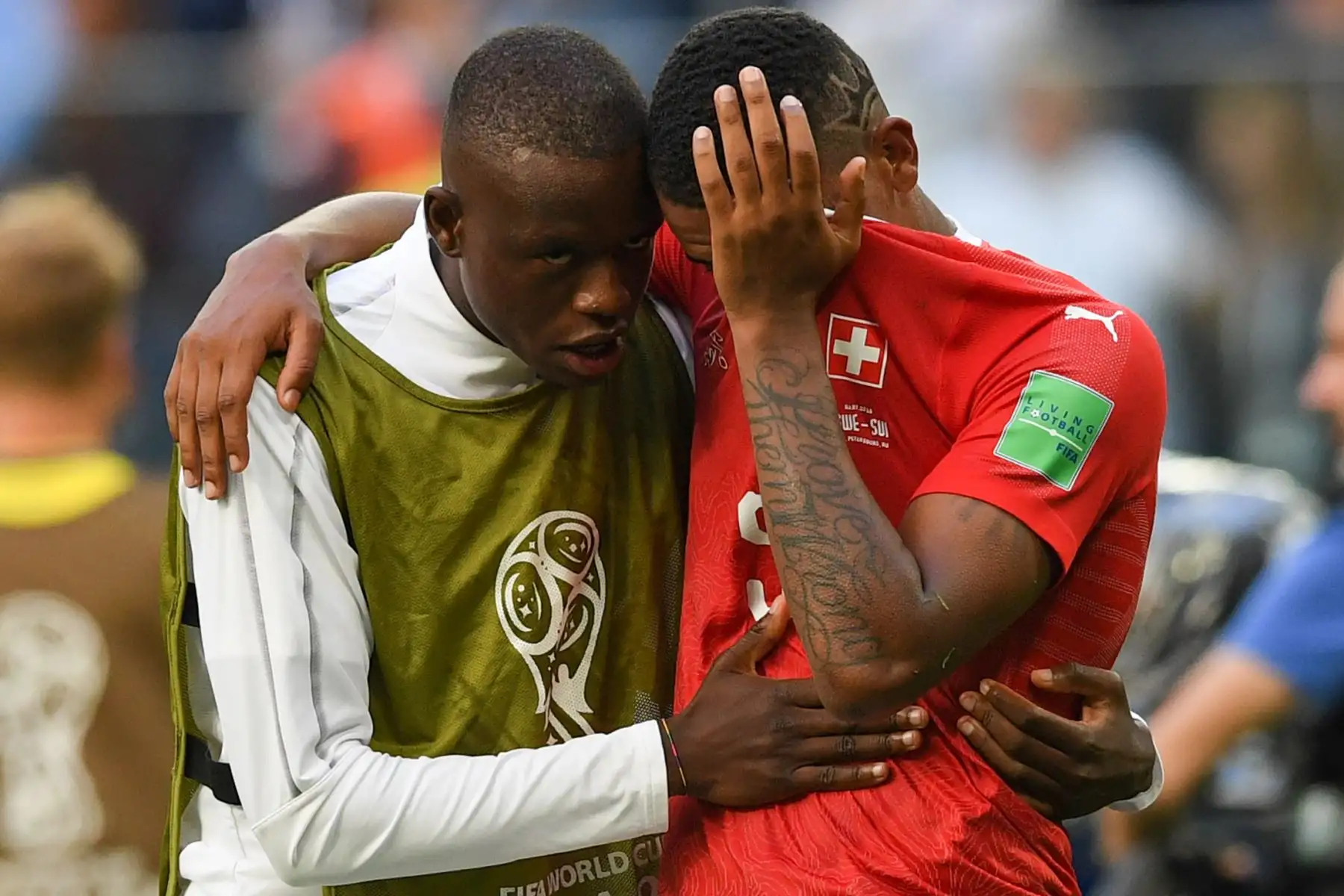 El mediocampista suizo Gelson Fernandes (L) consuela al defensor Manuel Akanji después de que el equipo perdiera la ronda de octavos de final de la Copa Mundial Rusia 2018 entre Suecia y Suiza en el estadio San Petersburgo de San Petersburgo el 3 de julio de 2018. / AFP