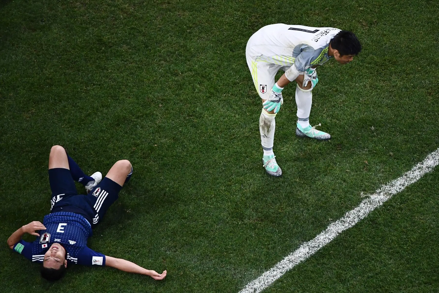 El defensor japonés Gen Shoji (L) y el portero japonés Eiji Kawashima reaccionan después de que los jugadores belgas anotaron su gol ganador durante la ronda de octavos de final de la Copa Mundial Rusia 2018 entre Bélgica y Japón en el Rostov Arena en Rostov-On-Don el 2 de julio de 2018 . / AFP