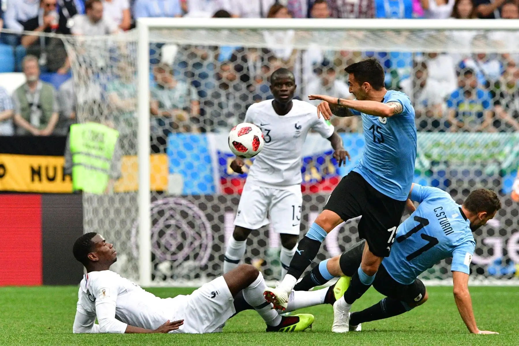 El centrocampista de Francia Paul Pogba (L) yace pasado el centrocampista uruguayo Matias Vecino (C) y el centrocampista francés N