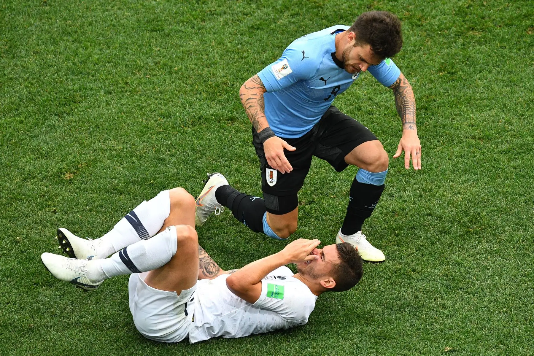 El defensa de Francia Lucas Hernández (abajo) reacciona después de una falta del centrocampista uruguayo Nahitan Nandez durante el partido de cuartos de final de la Copa Mundial Rusia 2018 entre Uruguay y Francia en el Estadio Nizhny Novgorod en Nizhny Novgorod el 6 de julio de 2018. / AFP