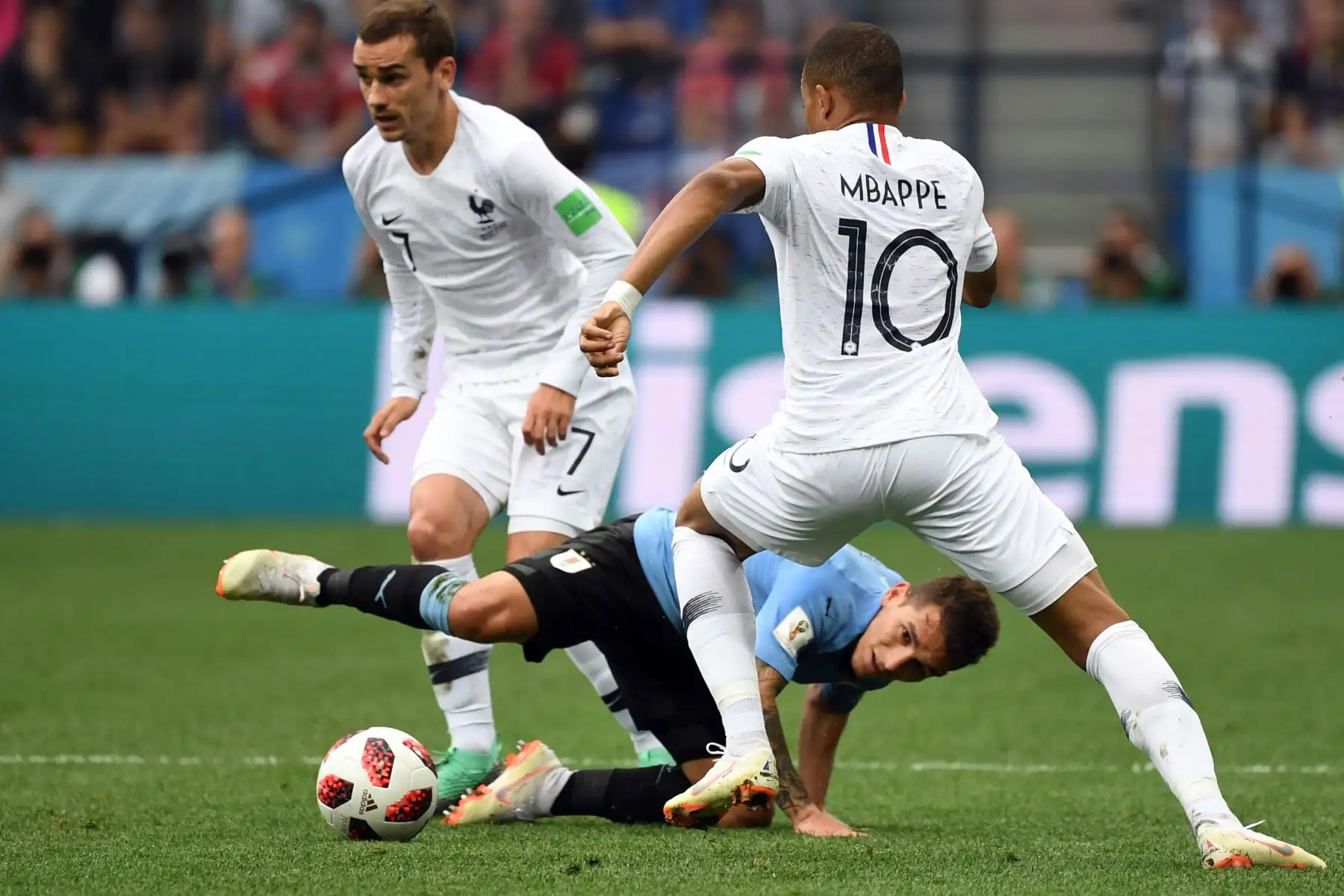 El centrocampista uruguayo Lucas Torreira (C) compite con el delantero francés Kylian Mbappe (R) ante el delantero francés Antoine Griezmann durante el partido de cuartos de final de la Copa del Mundo Rusia 2018 entre Uruguay y Francia en el Estadio Nizhny Novgorod en Nizhny Novgorod el 6 de julio de 2018. / AFP