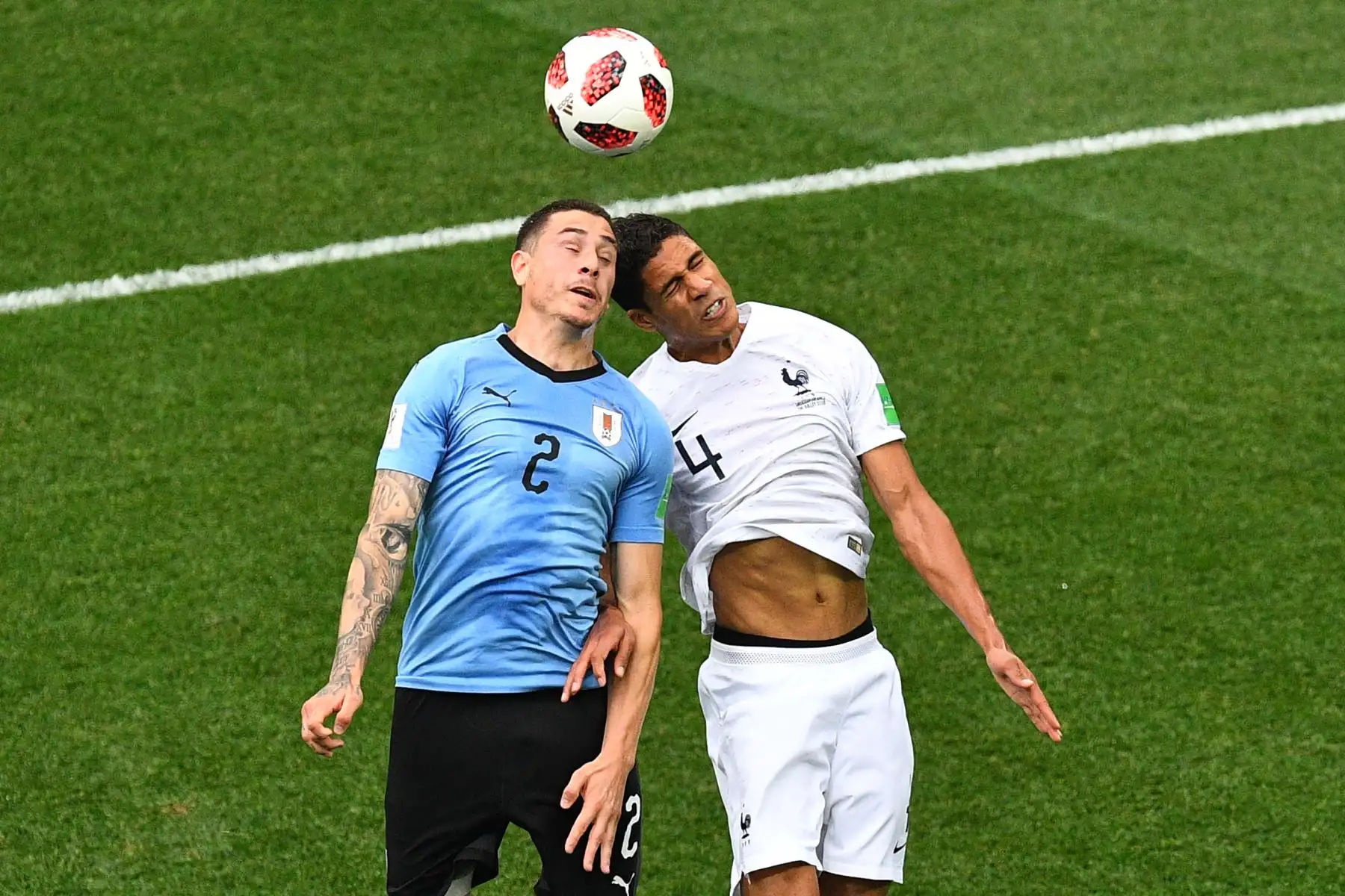 l defensor uruguayo José Giménez (L) compite por el cabezazo con el defensor francés Raphael Varane durante el partido de cuartos de final de la Copa del Mundo Rusia 2018 entre Uruguay y Francia en el Estadio Nizhny Novgorod en Nizhny Novgorod el 6 de julio de 2018. / AFP