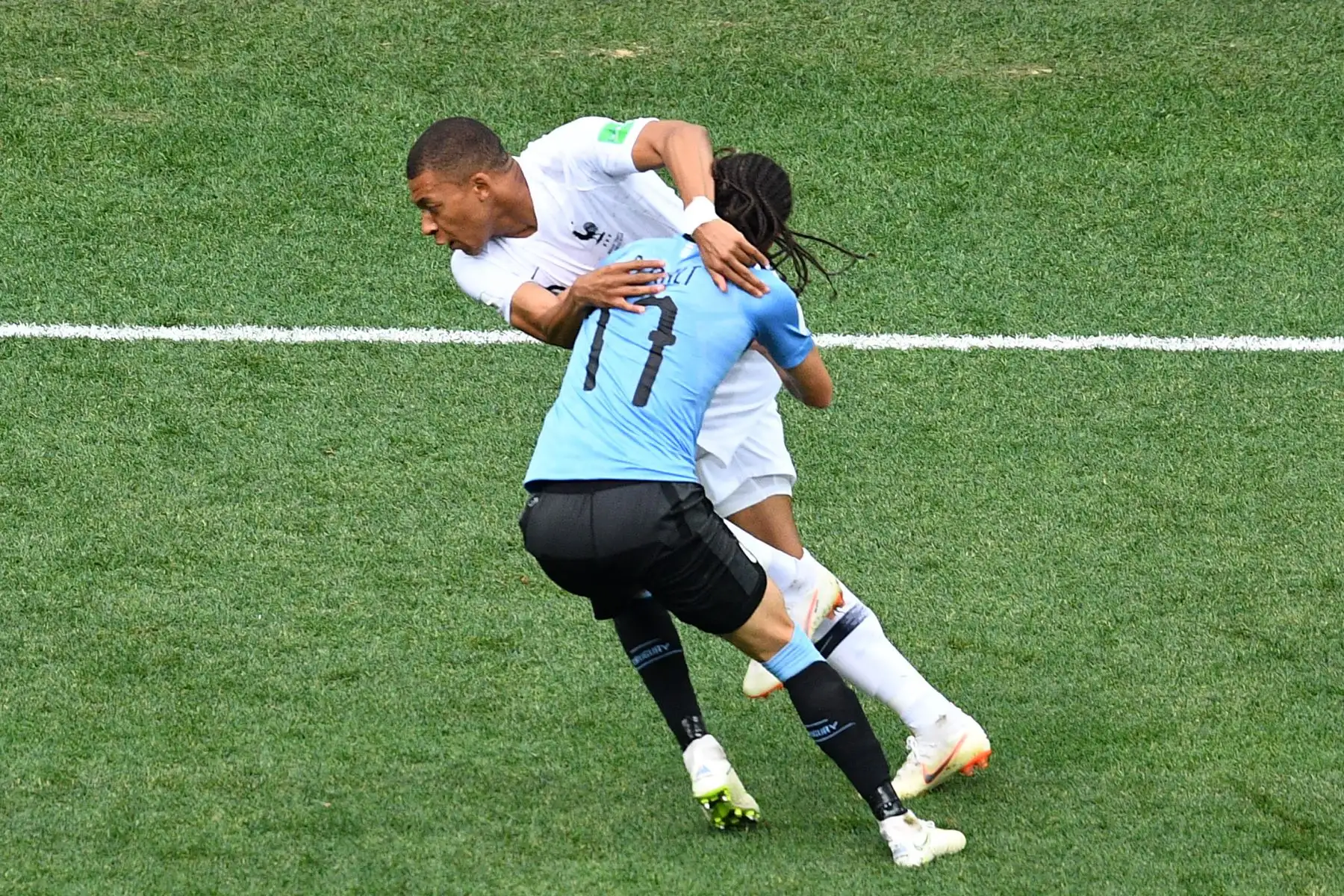 El defensor uruguayo Diego Laxalt (R) compite por el balón con el delantero francés Kylian Mbappe durante el partido de cuartos de final de la Copa Mundial Rusia 2018 entre Uruguay y Francia en el Estadio Nizhny Novgorod en Nizhny Novgorod el 6 de julio de 2018. / AFP