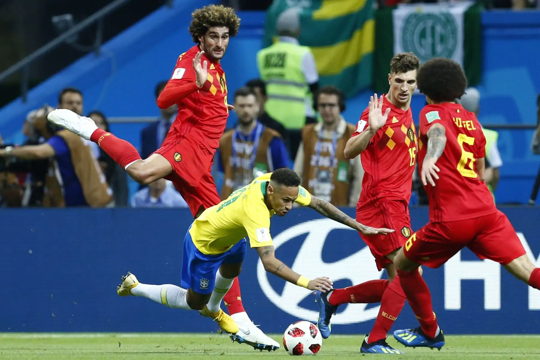 El delantero brasileño Neymar (2L) cae en el campo mientras compite con el centrocampista belga Marouane Fellaini (L) durante el partido de fútbol de cuartos de final de la Copa Mundial Rusia 2018 entre Brasil y Bélgica en el Kazan Arena en Kazán el 6 de julio de 2018. / AFP