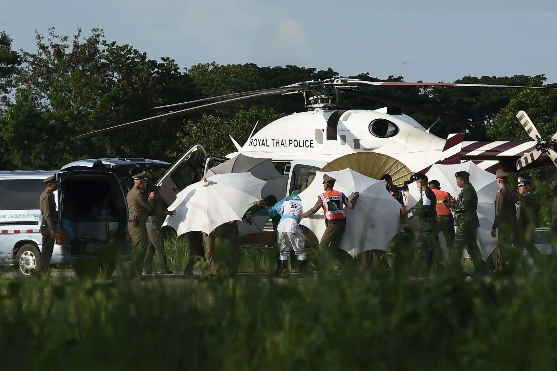 Los trabajadores de rescate llevan una camilla cerca de un helicóptero de la policía en un aeropuerto militar en Chiang Rai el 9 de julio de 2018, mientras continúan las operaciones de rescate para los que aún están atrapados dentro de la cueva en Khun Nam Nang Non Forest Park en el distrito de Mae Sai. AFP