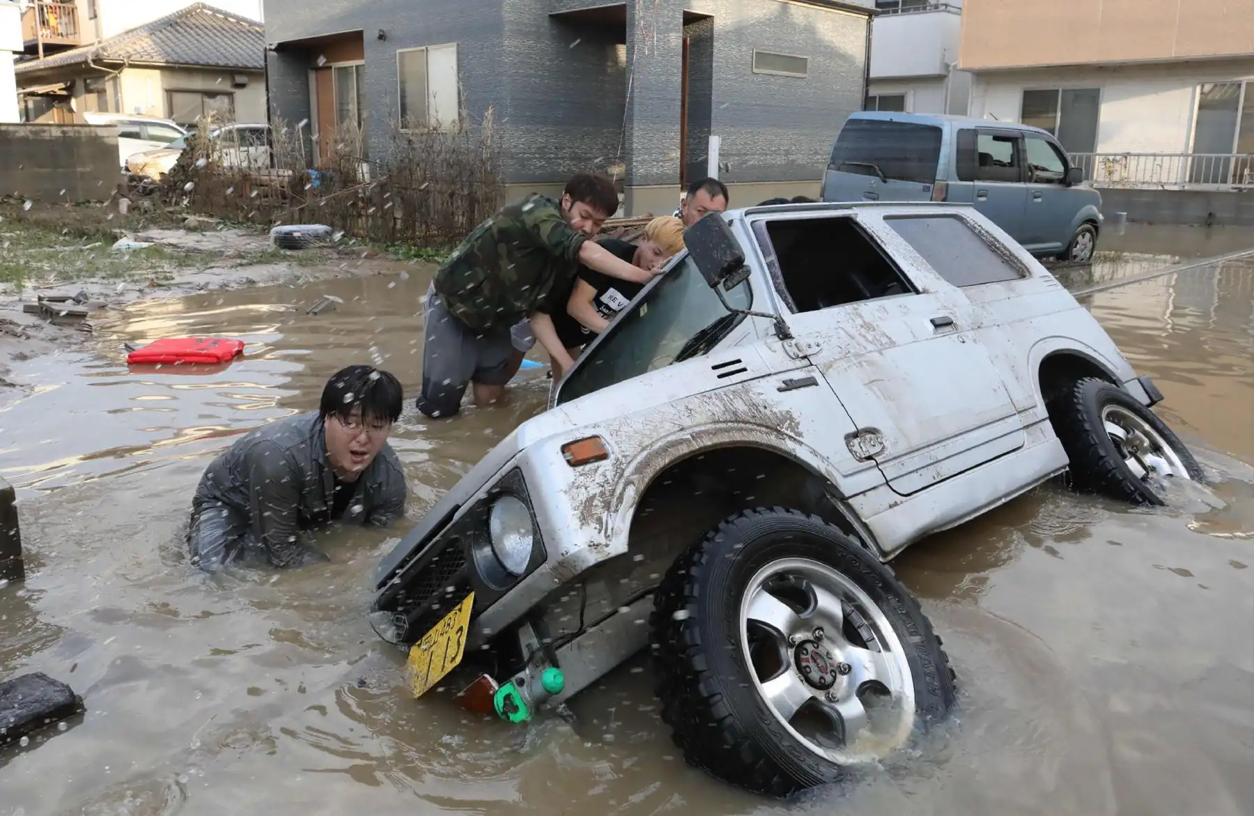 Los residentes intentan enderezar un vehículo atascado en una zona afectada por las inundaciones en Kurashiki, prefectura de Okayama el 9 de julio de 2018.
Los trabajadores de rescate, la policía y las tropas en Japón lucharon el 9 de julio para llegar a las personas que se temían atrapadas por las devastadoras inundaciones y deslizamientos de tierra después de días de precipitaciones que mataron al menos a 75 personas. / AFP