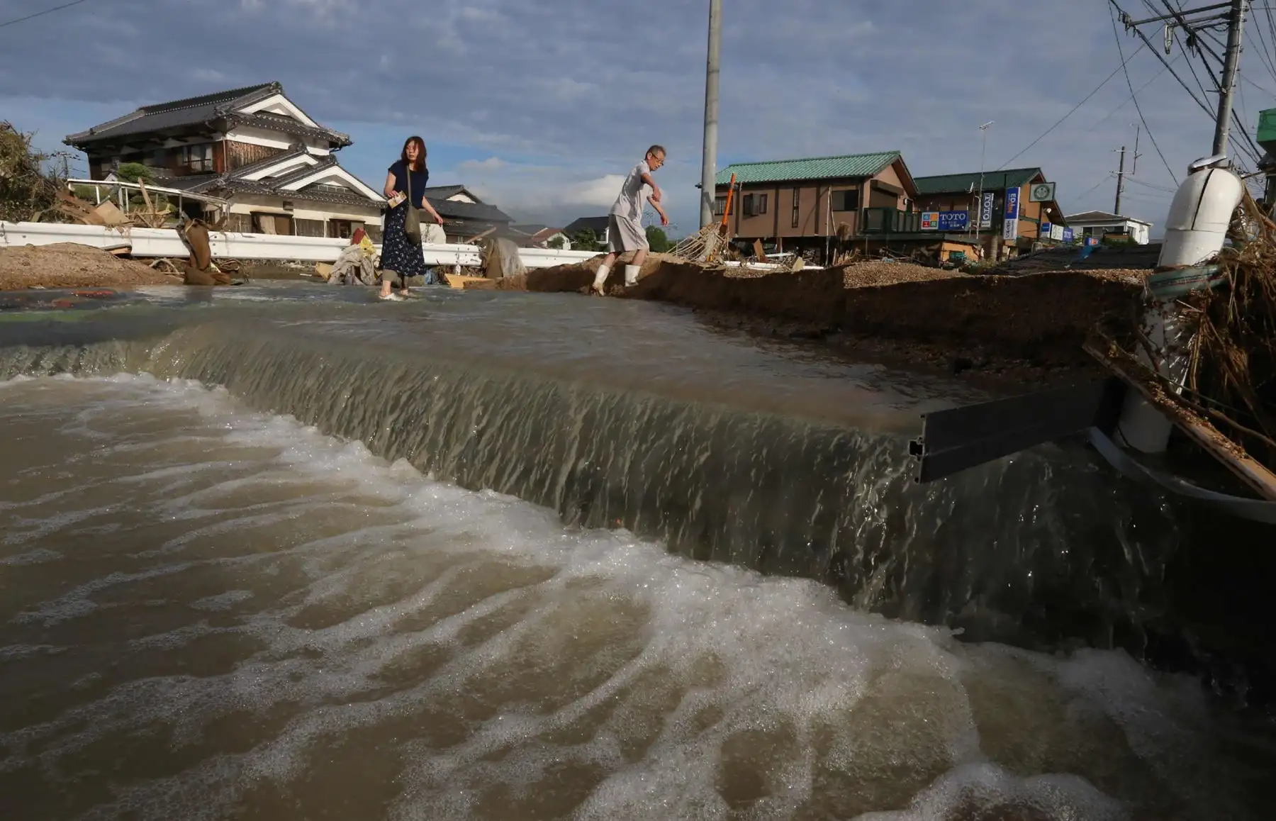 Los residentes cruzan una zona todavía inundada en Kurashiki, prefectura de Okayama el 9 de julio de 2018.
Los trabajadores de rescate, la policía y las tropas en Japón lucharon el 9 de julio para llegar a las personas que se temían atrapadas por las devastadoras inundaciones y deslizamientos de tierra después de días de precipitaciones que mataron al menos a 75 personas. / AFP